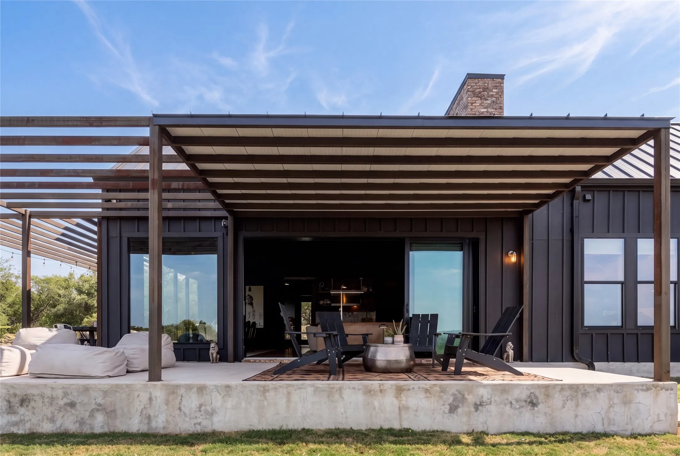 An expansive covered concrete patio connects seamlessly to the home through large sliding doors.
