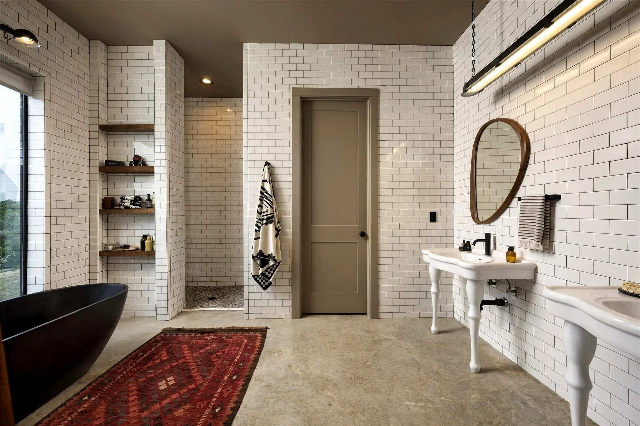 Polished concrete floors and classic subway tile create a sophisticated, modern industrial aesthetic.