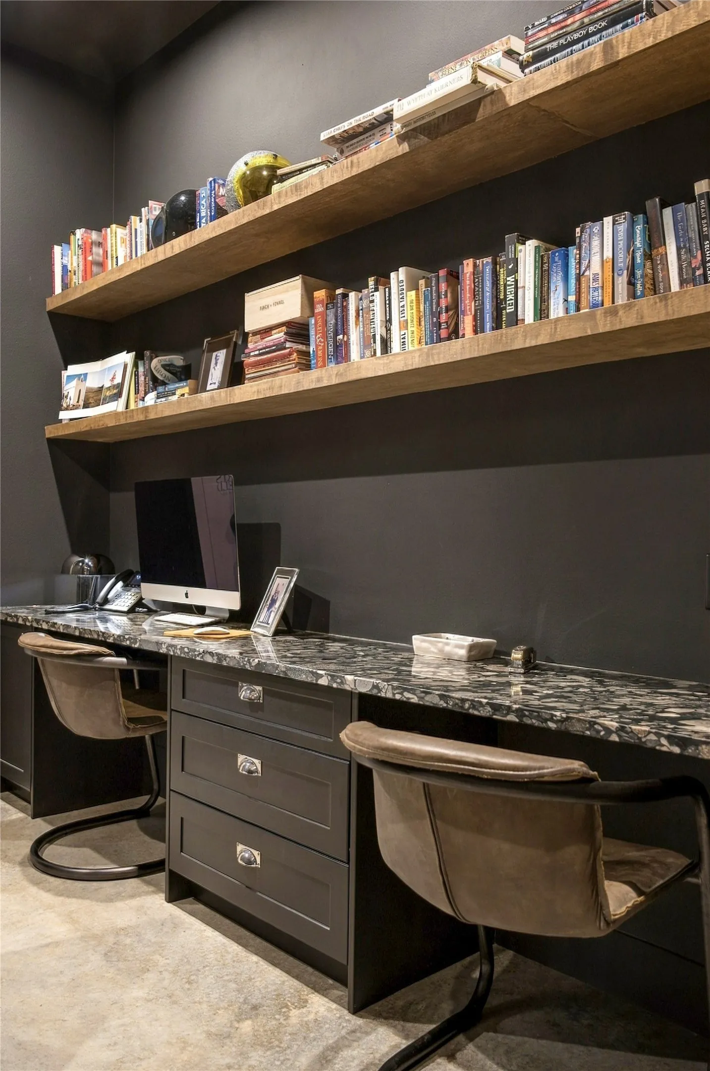 Custom built-in shelving and polished natural stone countertops elevate this dedicated workspace.