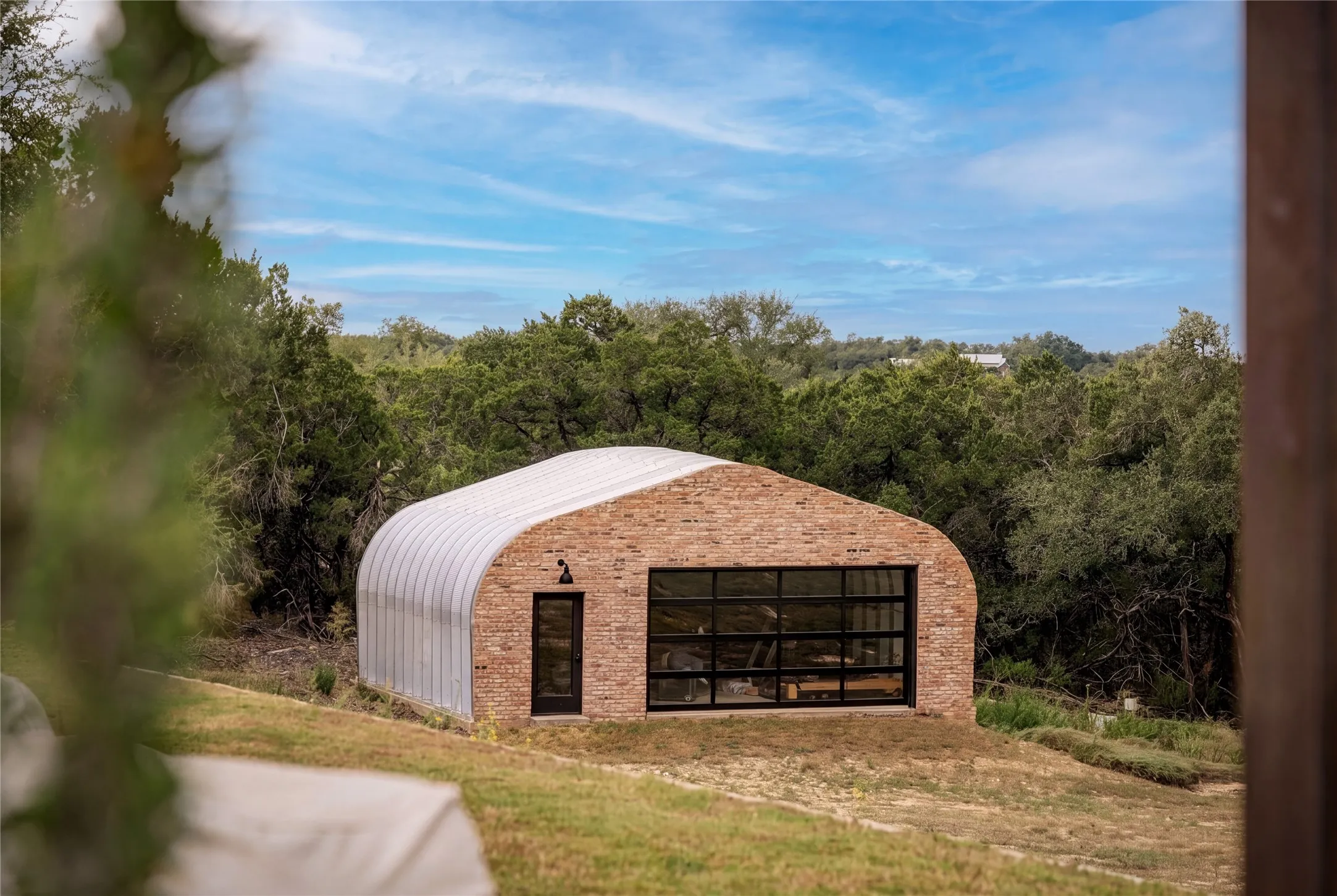 The Quonset hut is currently used as a spacious gym complete with a mini-split, bar and half bath.