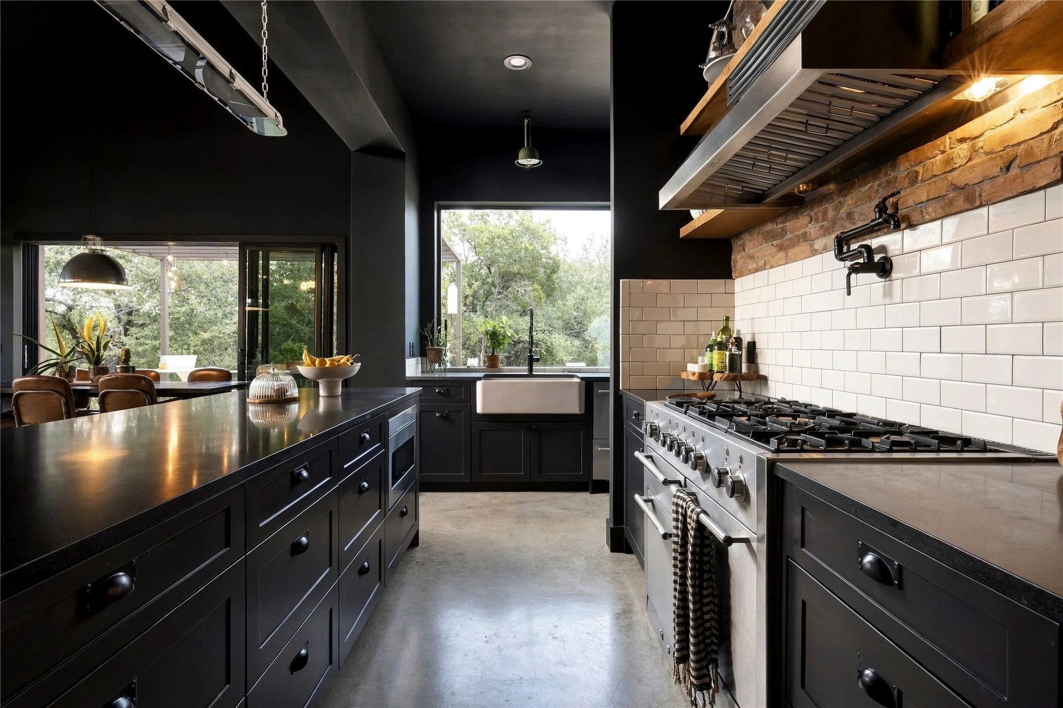Polished concrete floors and exposed Chicago brick accents frame this sleek culinary workspace.