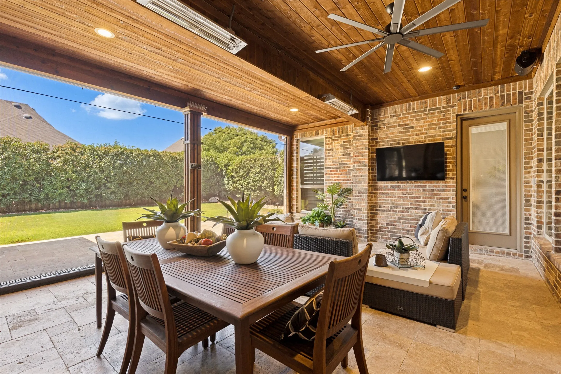 Covered travertine patio with TV and automated screens