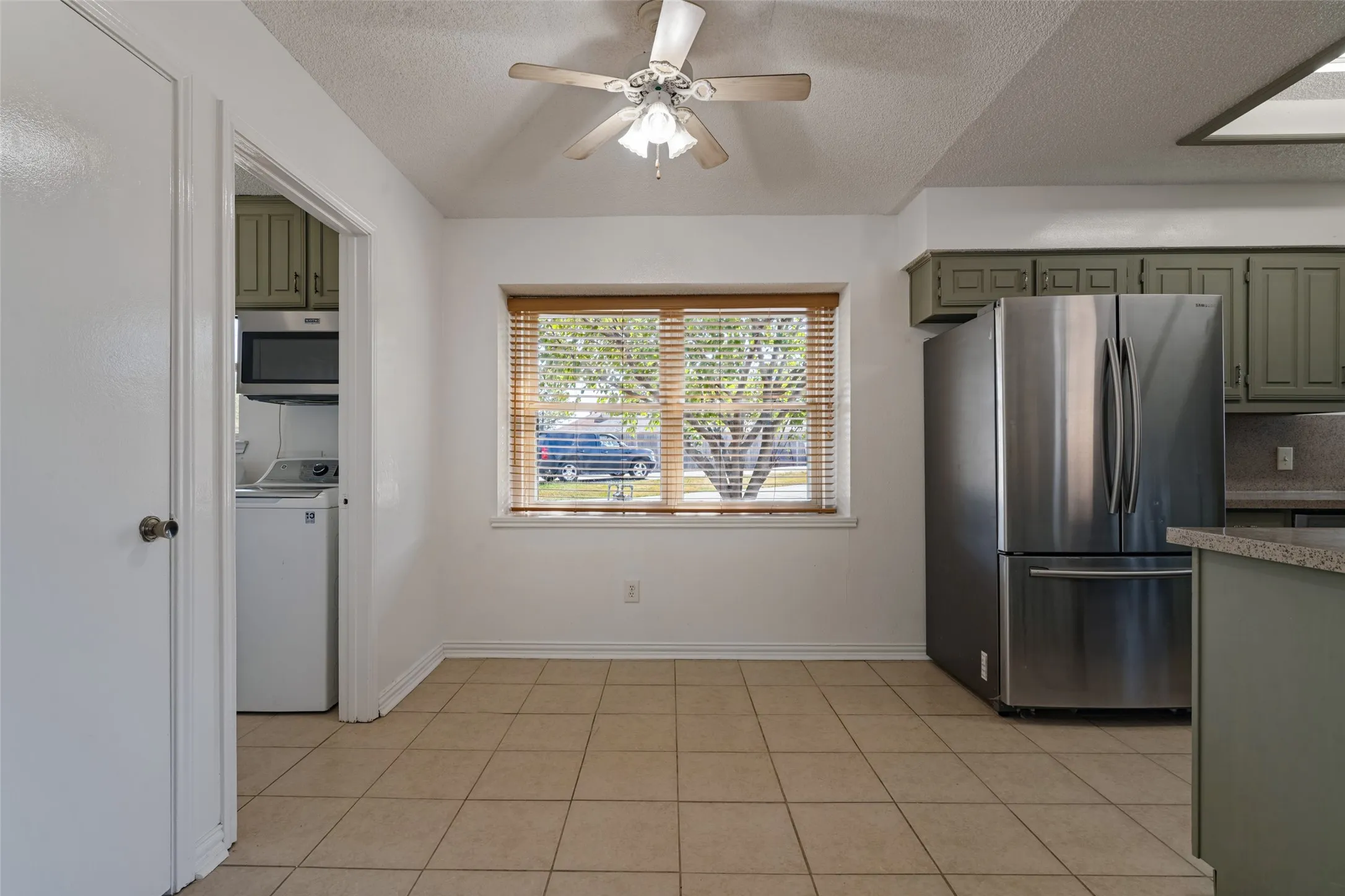 Dining area with box window with wood-finish blinds.