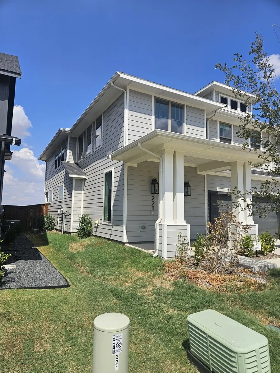 Gray siding exterior with white trim, featuring a covered entry