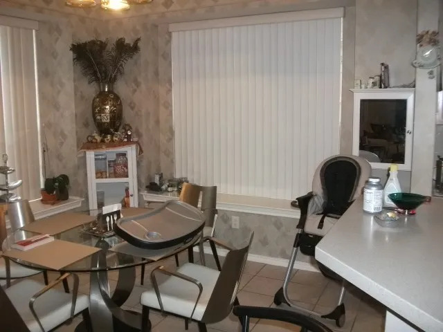Patterned wallpaper, window blinds, built-in shelving, and tiled flooring