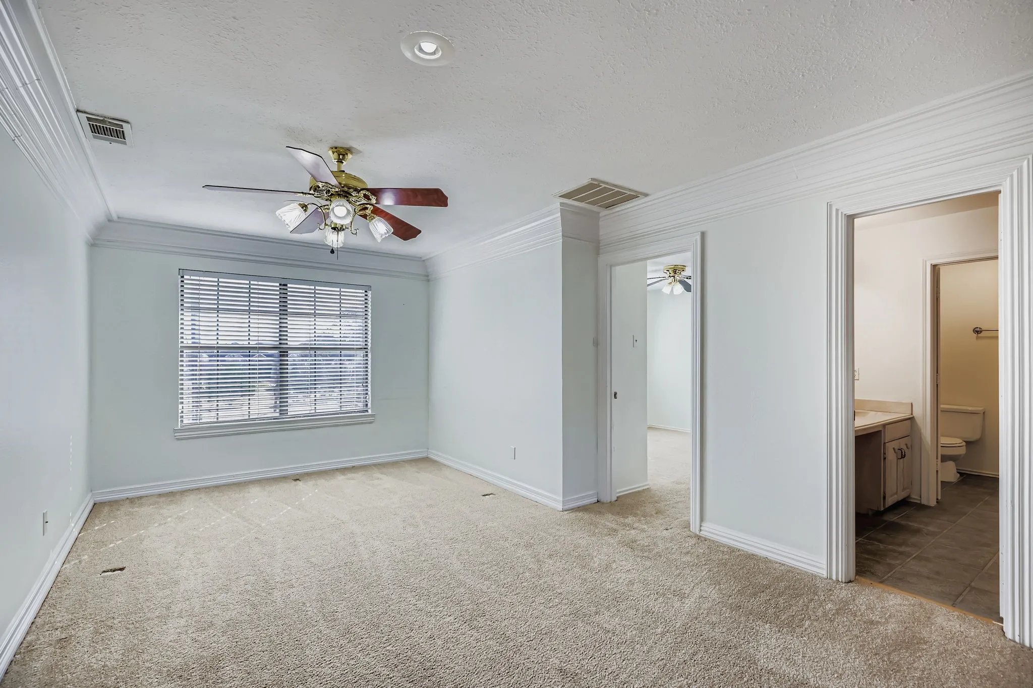 Carpeted room with crown molding, a ceiling fan with light fixture, and recessed lighting