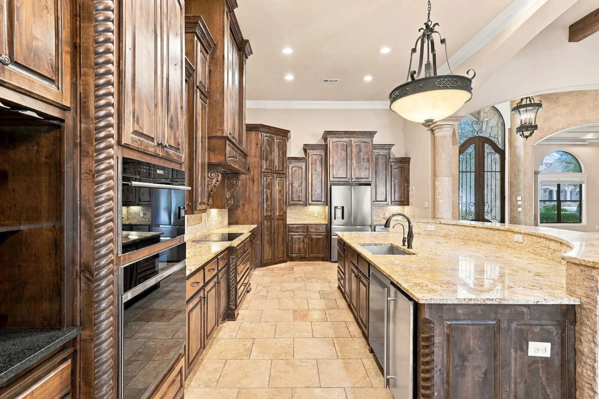 Gourmet kitchen featuring custom wood cabinetry, integrated stainless steel appliances, granite countertops, and tile flooring