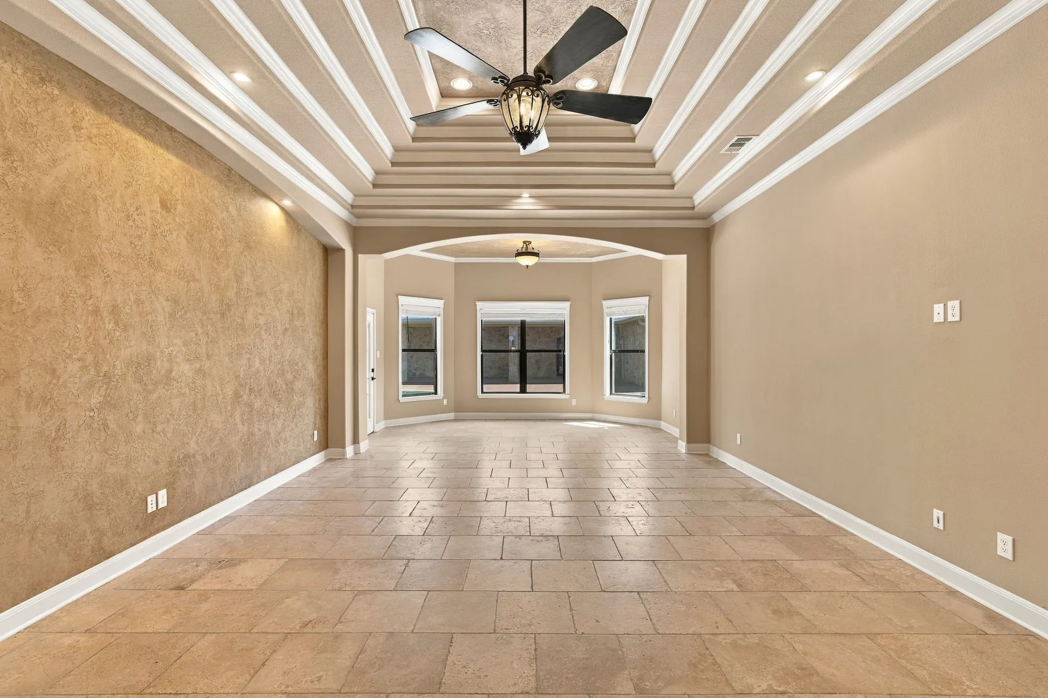 Vaulted ceiling with decorative beams, recessed lighting, ceiling fan light fixture, rectangular tile flooring, and a bay window