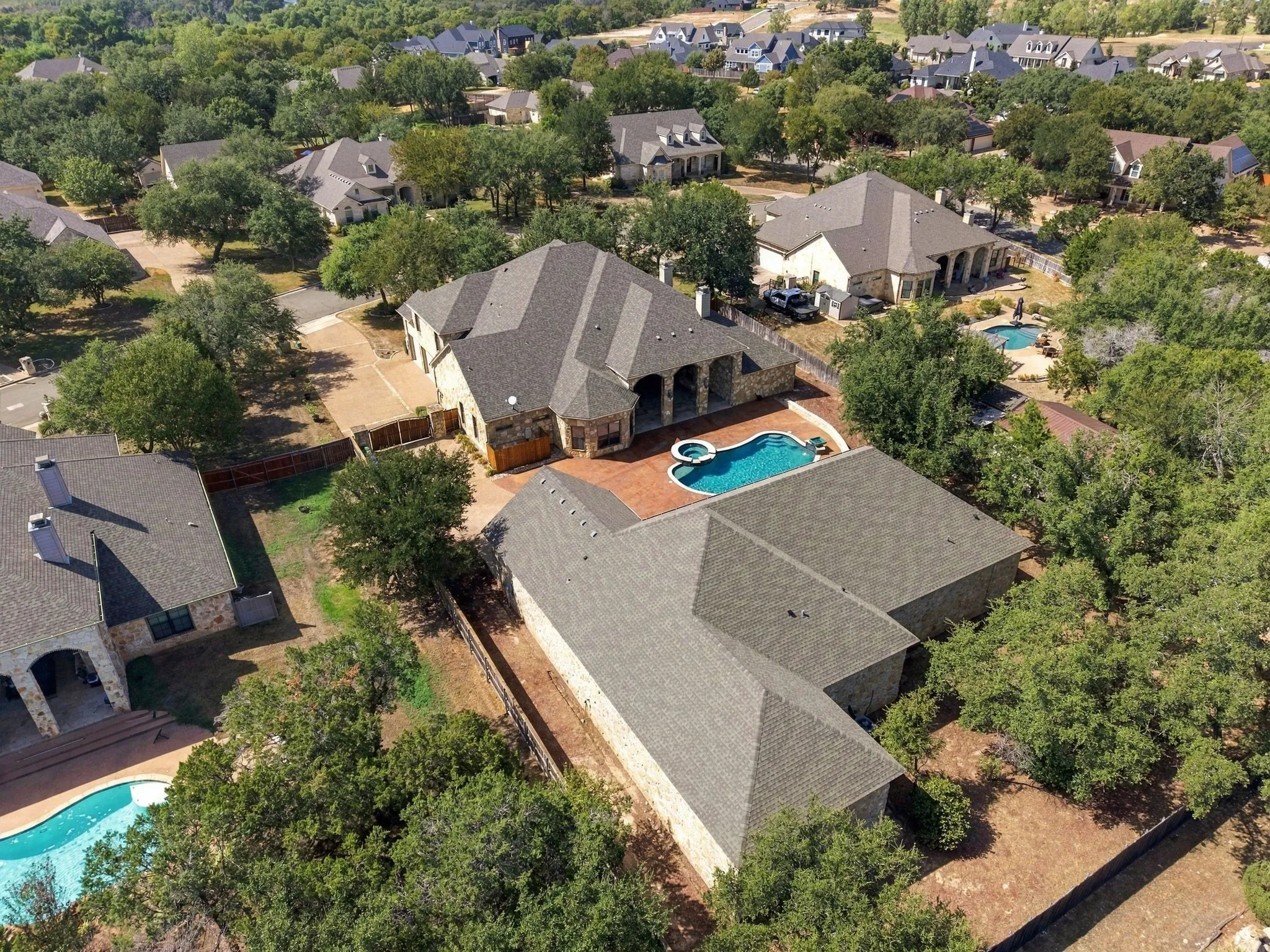 Exterior stone facade with gray shingle roofing