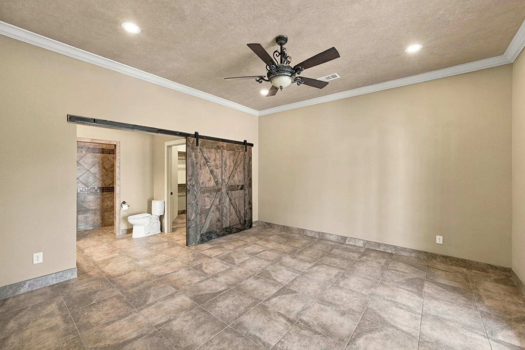 Spacious interior featuring large format floor tiling, a decorative ceiling fan, and recessed lighting