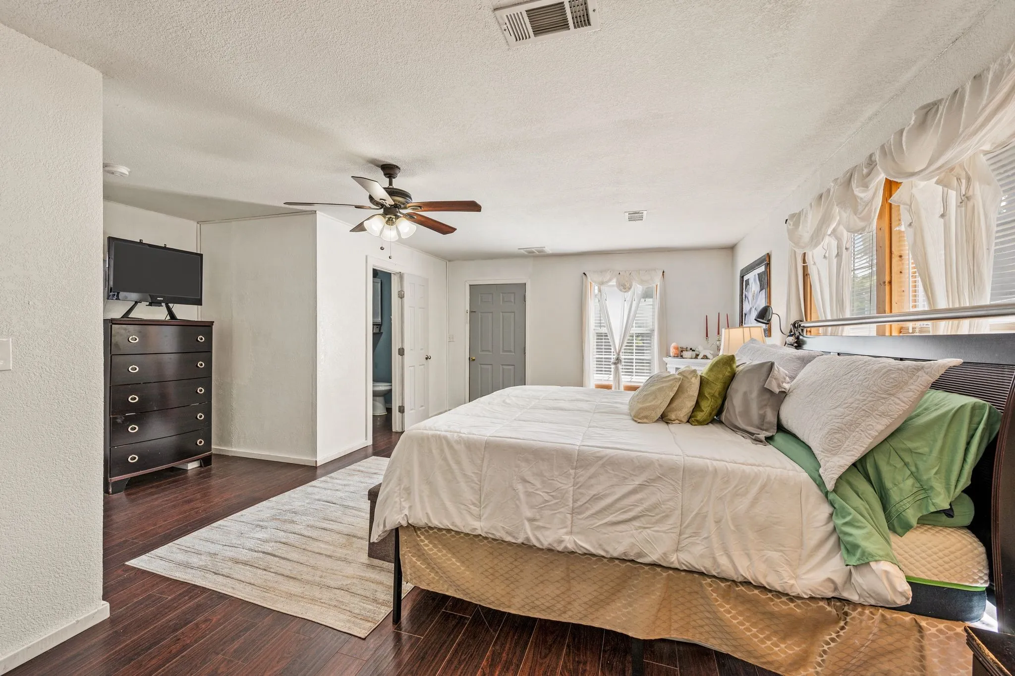  Ceiling fan with integrated lighting, multiple windows, and a white interior door