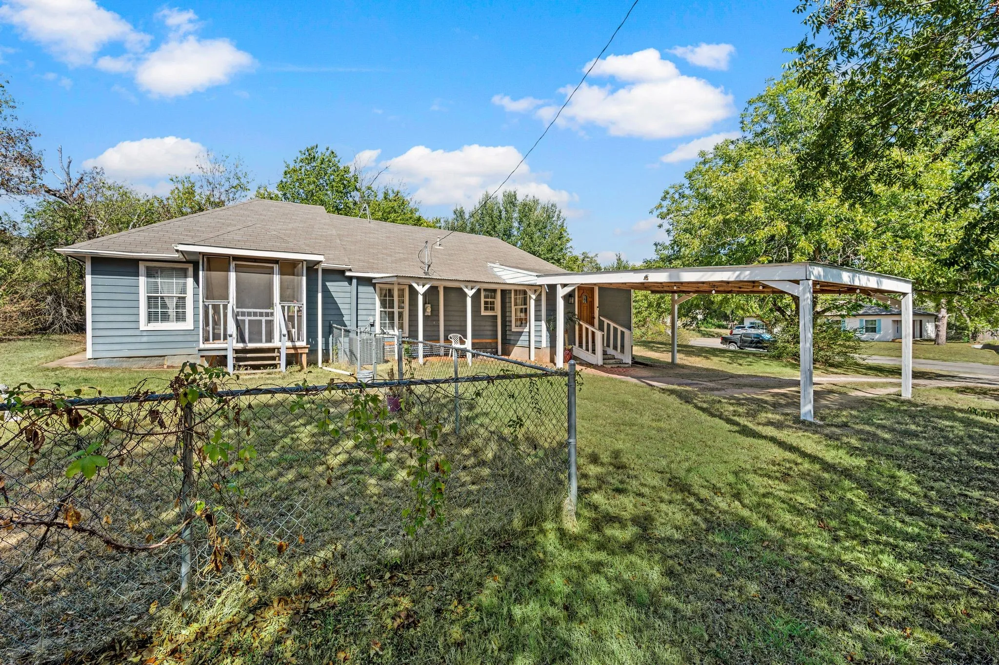 Single-story residence featuring blue siding and a covered carport