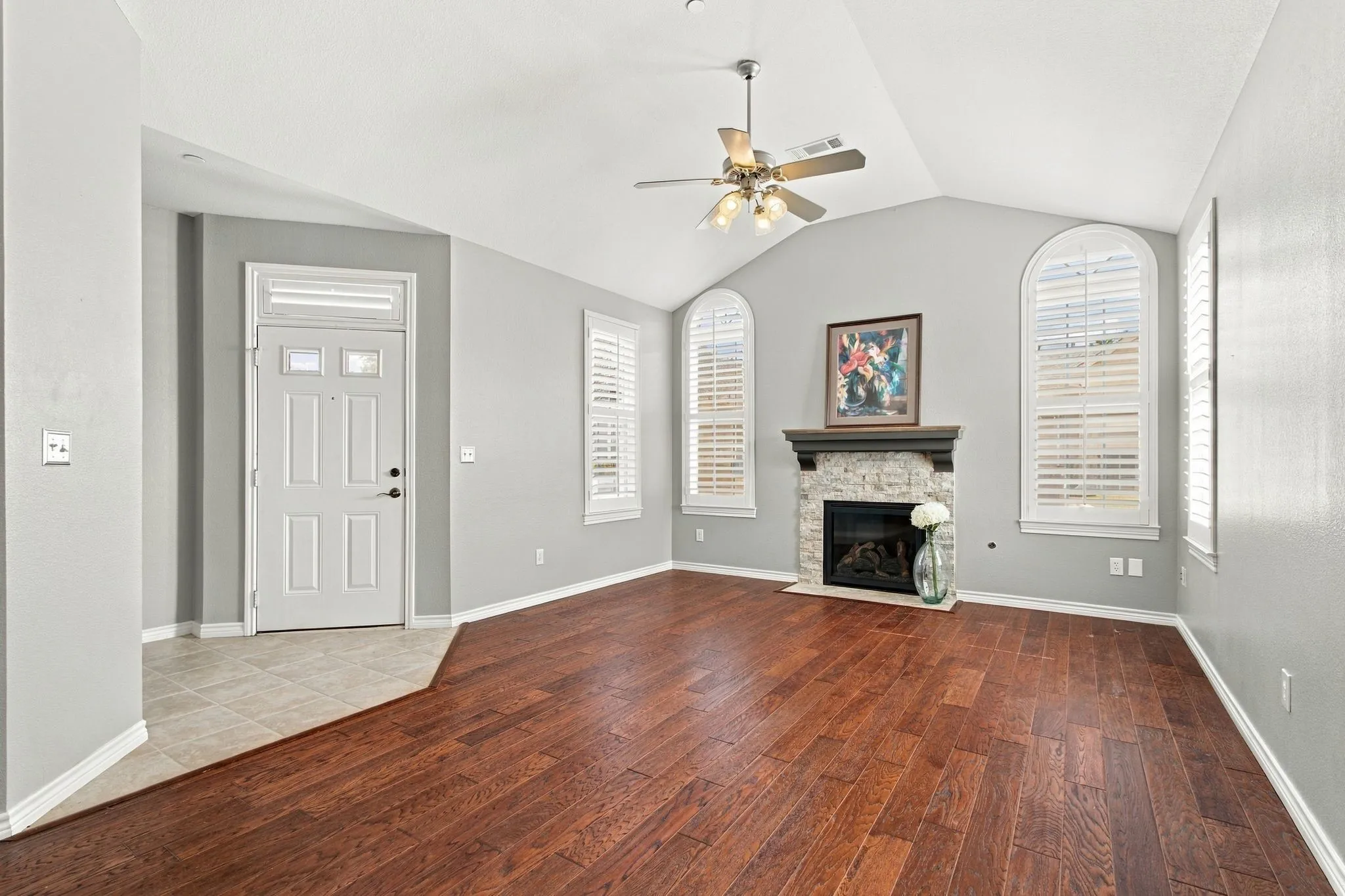 Living Room Open Area with Vaulted Ceilings and Plantations Shutters and Remodeled Fireplace