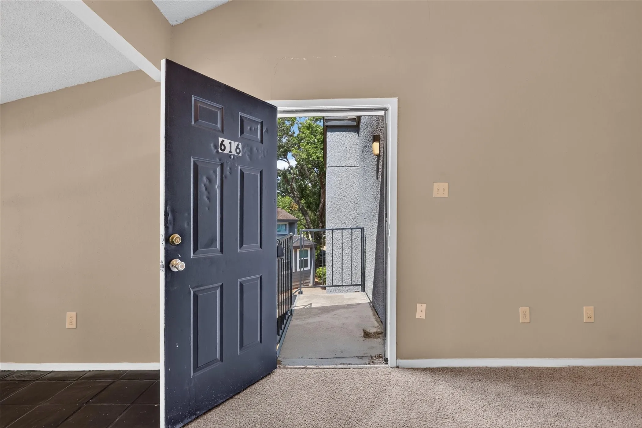 Entry door with paneled design opening to an exterior balcony