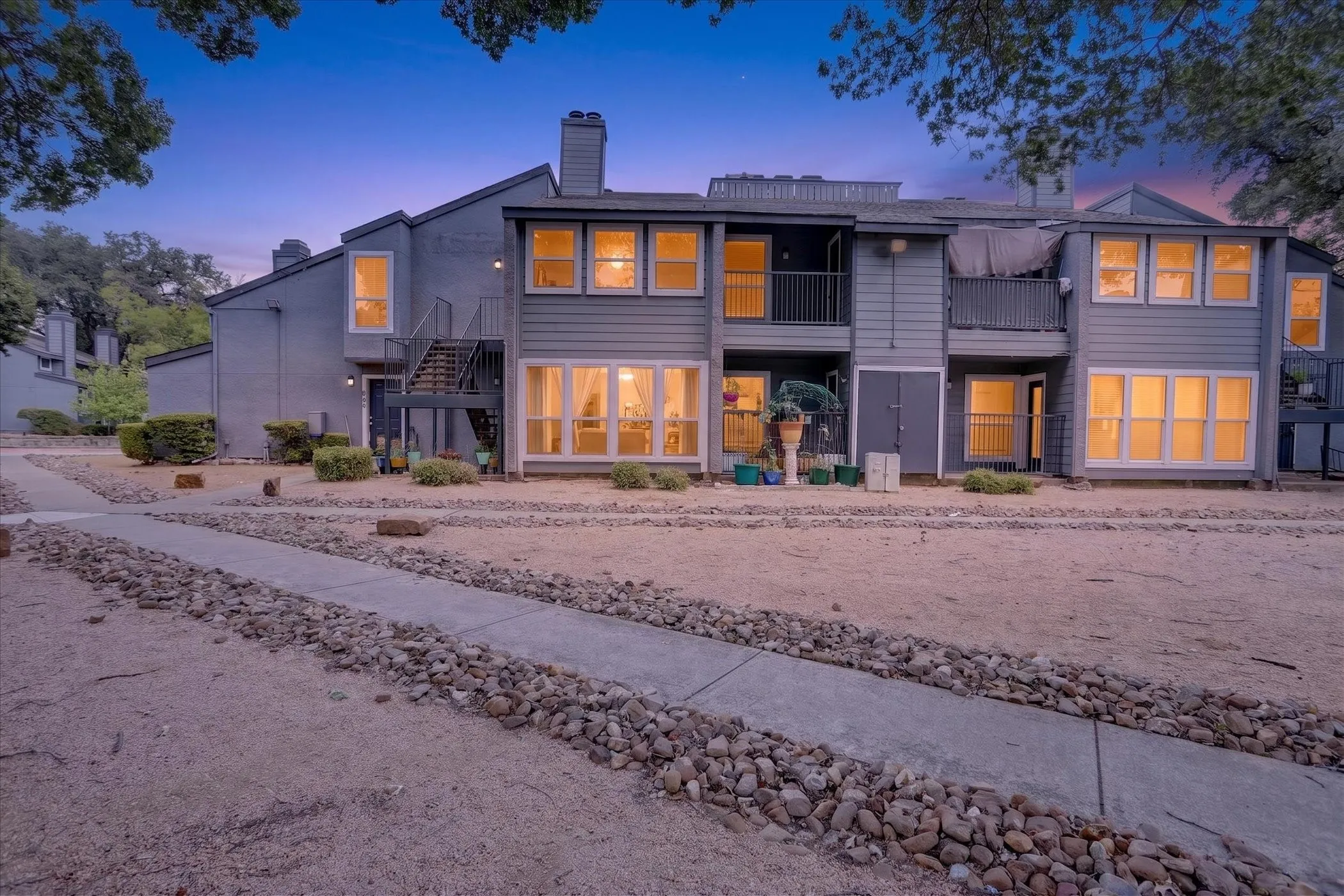 Two-story exterior with multiple balconies and ground-level patios