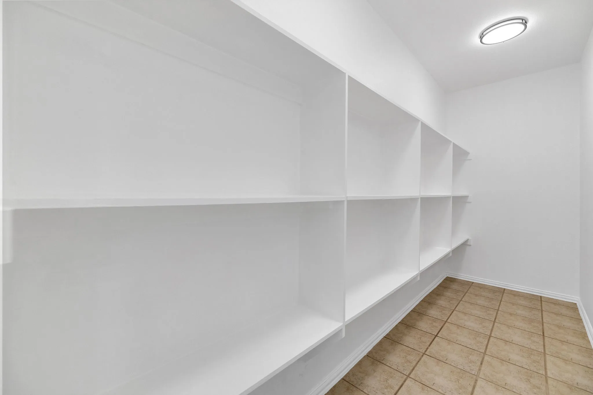Built-in shelving, recessed ceiling light fixture, and tile flooring