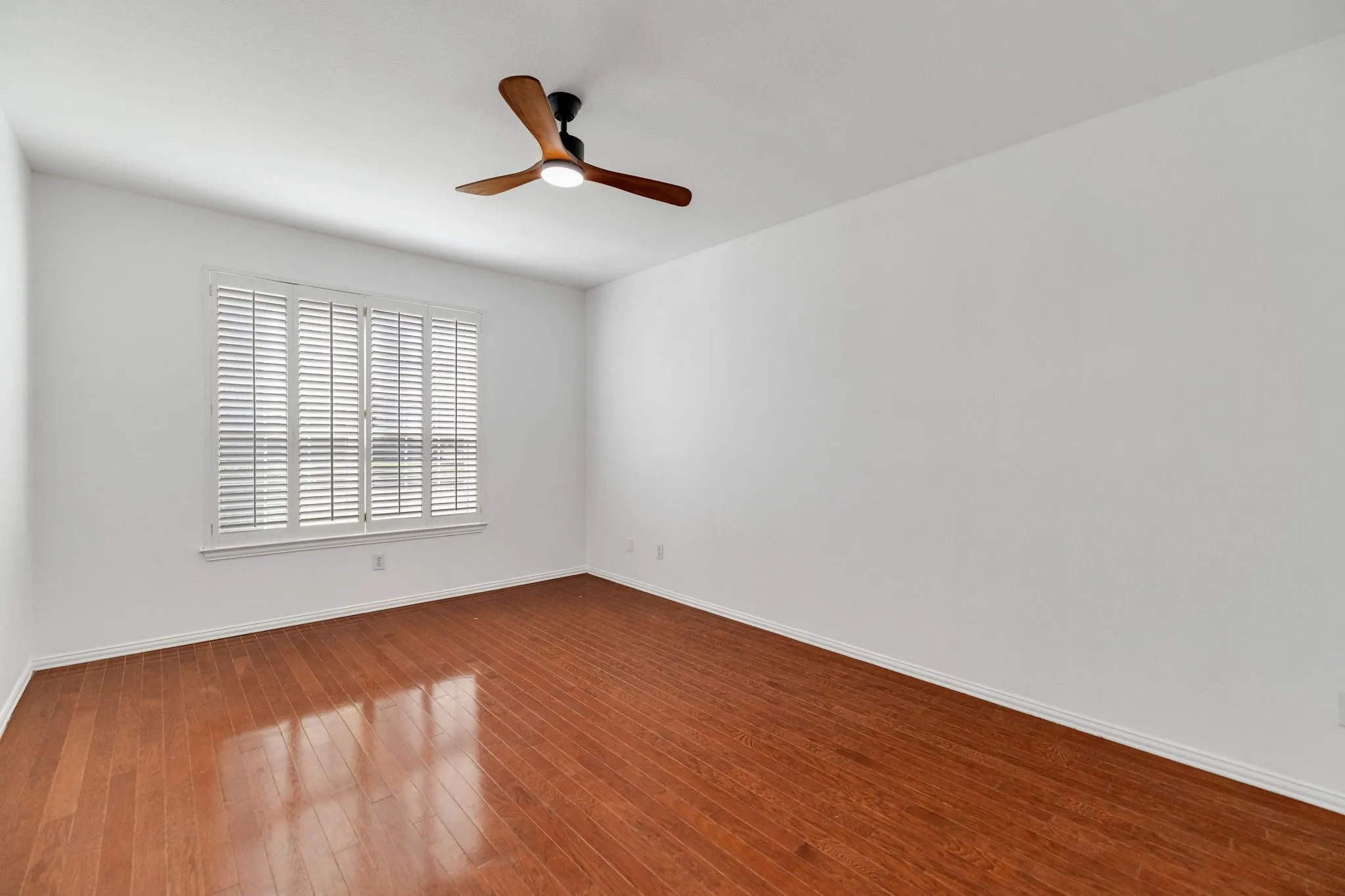 Hardwood flooring, plantation shutters, and a ceiling fan