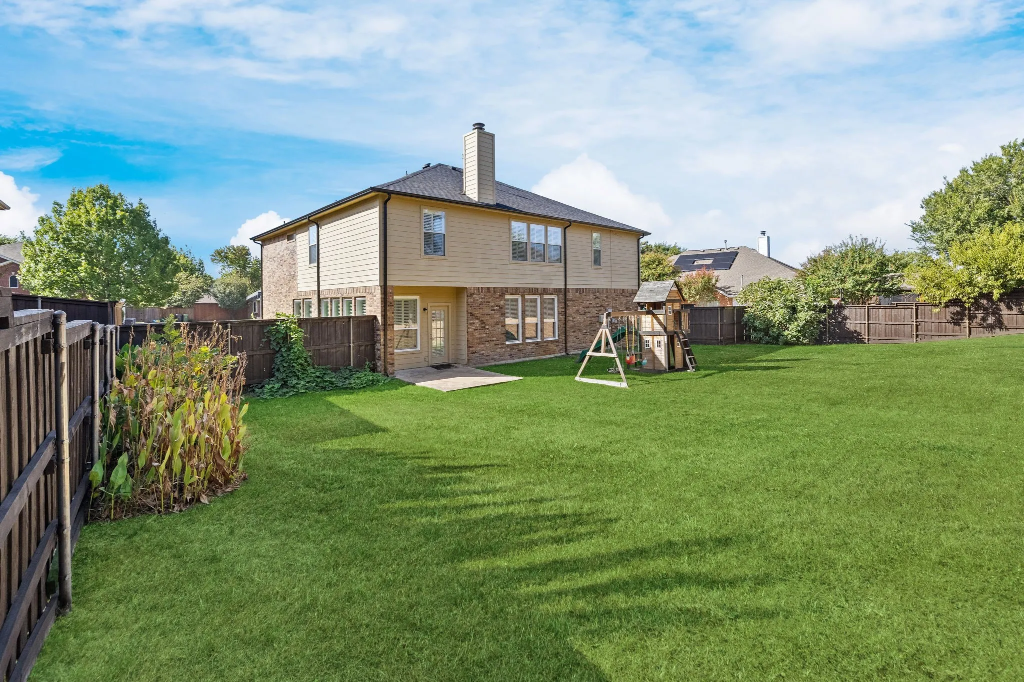 Expansive green lawn with a privacy fence