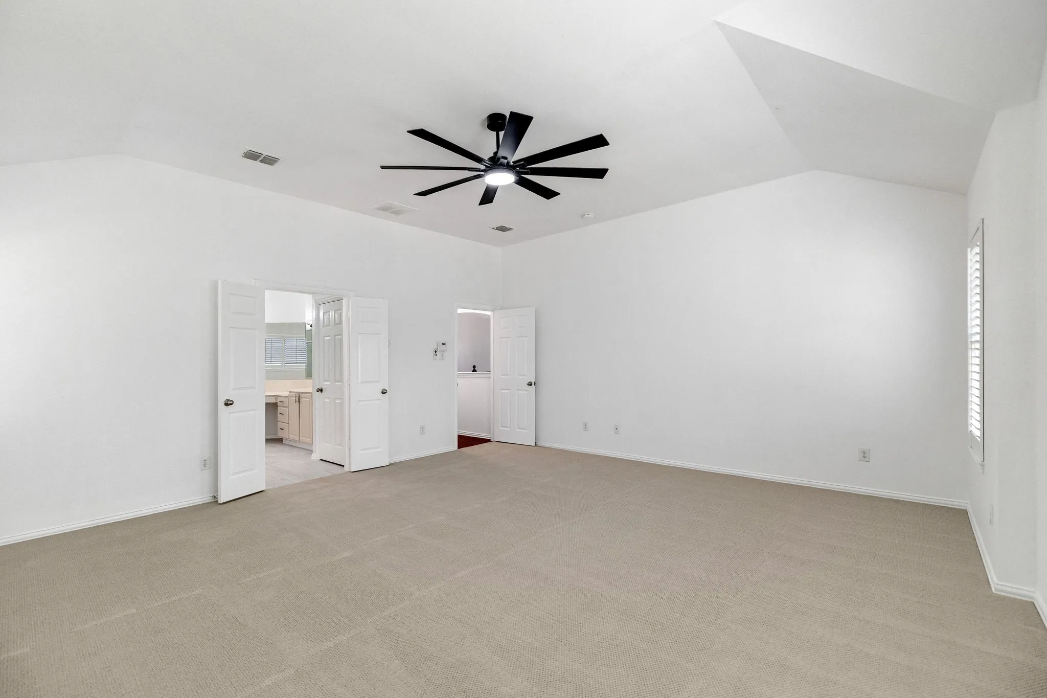 Spacious room with vaulted ceilings and recessed lighting