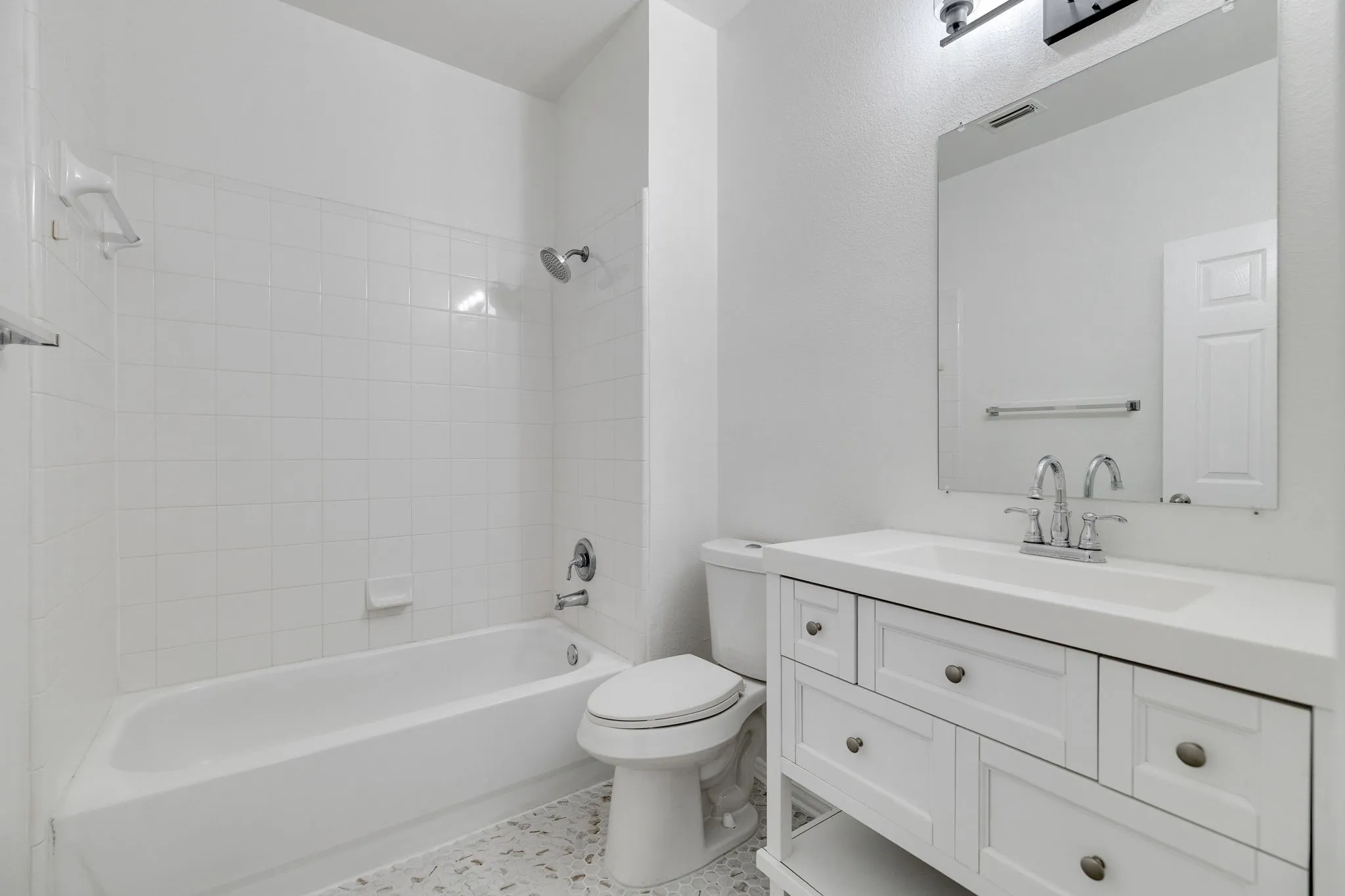 White vanity with integrated sink, chrome faucet, and rectangular mirror