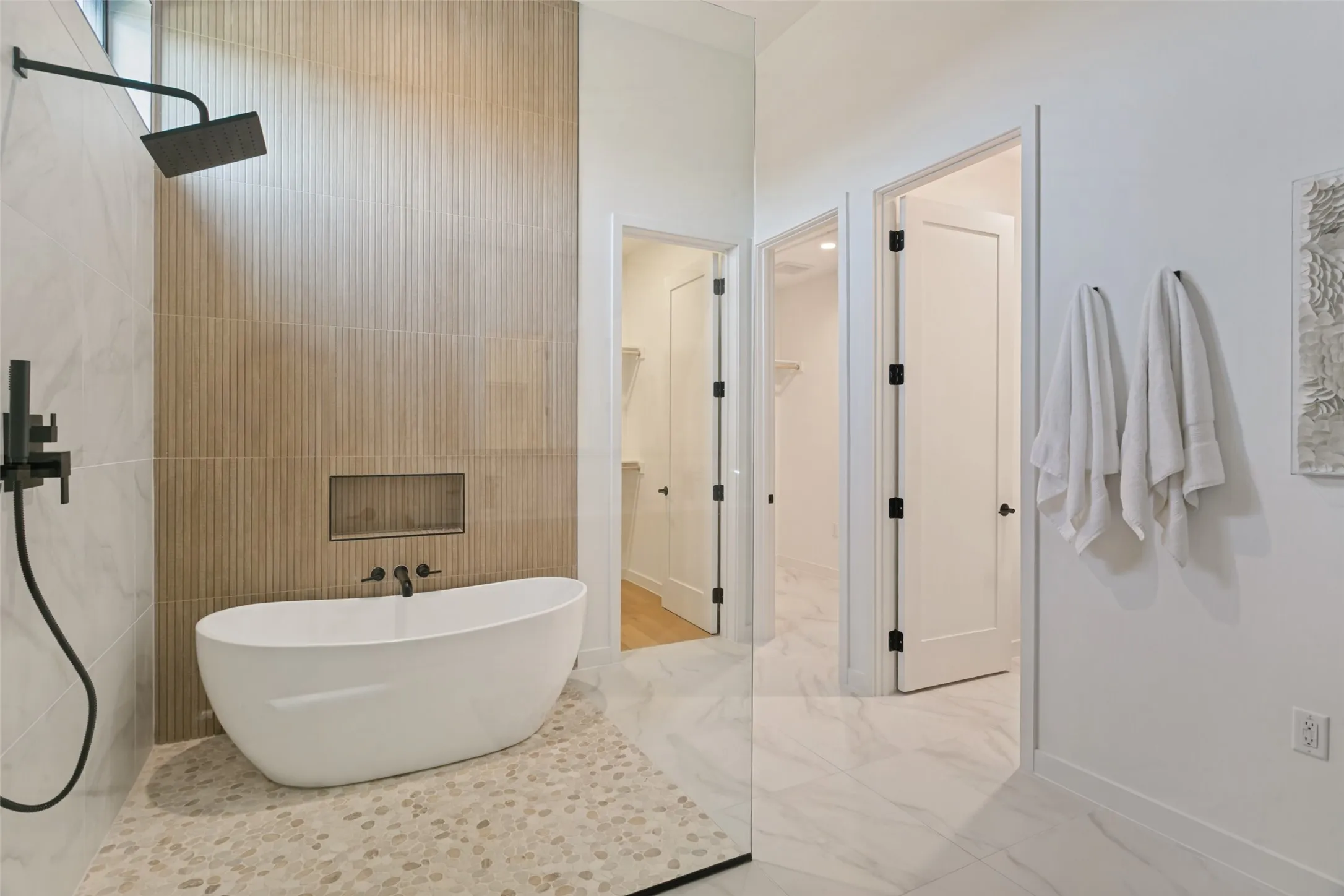 Freestanding soaking tub and rain shower in wet room.  Closet, laundry, and toilet area attached.