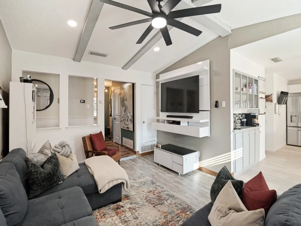 Vaulted ceiling with exposed beams and a ceiling fan