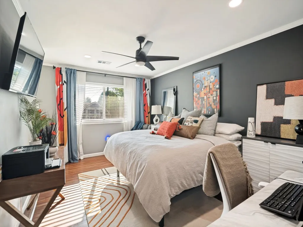Recessed lighting, crown molding, a ceiling fan with integrated lighting, wood-finish flooring, and a large window with blinds