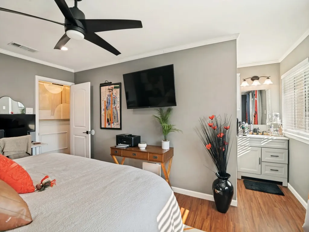 Wood-finish flooring throughout, complemented by a modern ceiling fan with integrated lighting