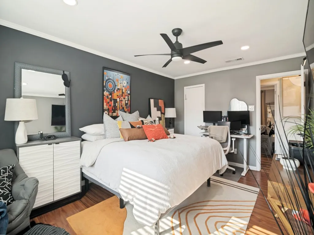 Wood-finish flooring with a ceiling fan and recessed lighting