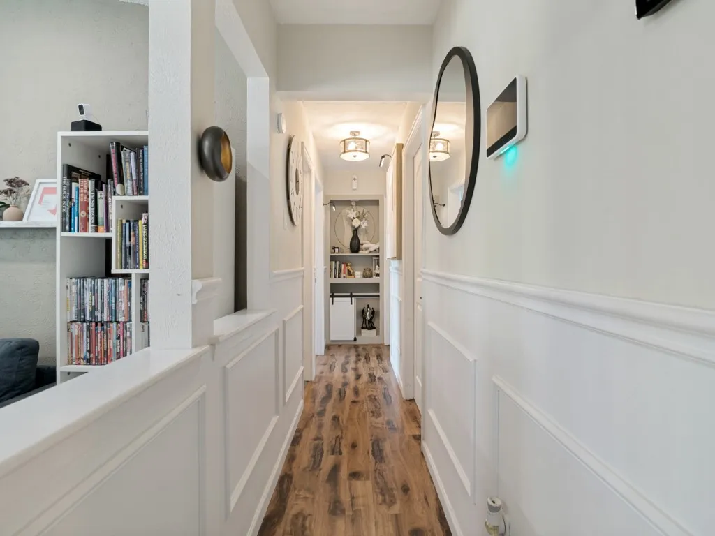 Hardwood-style flooring, wainscoting, recessed lighting, and built-in shelving