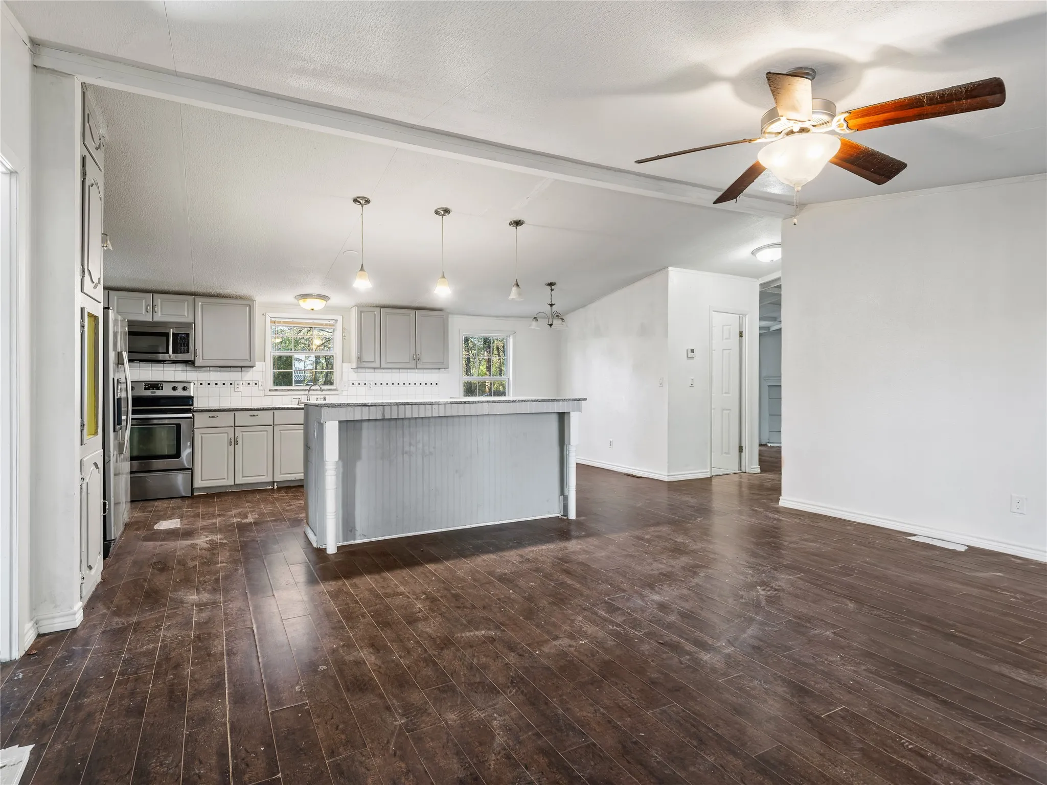 Kitchen featuring grey cabinetry, stainless steel appliances, and a tile backsplash