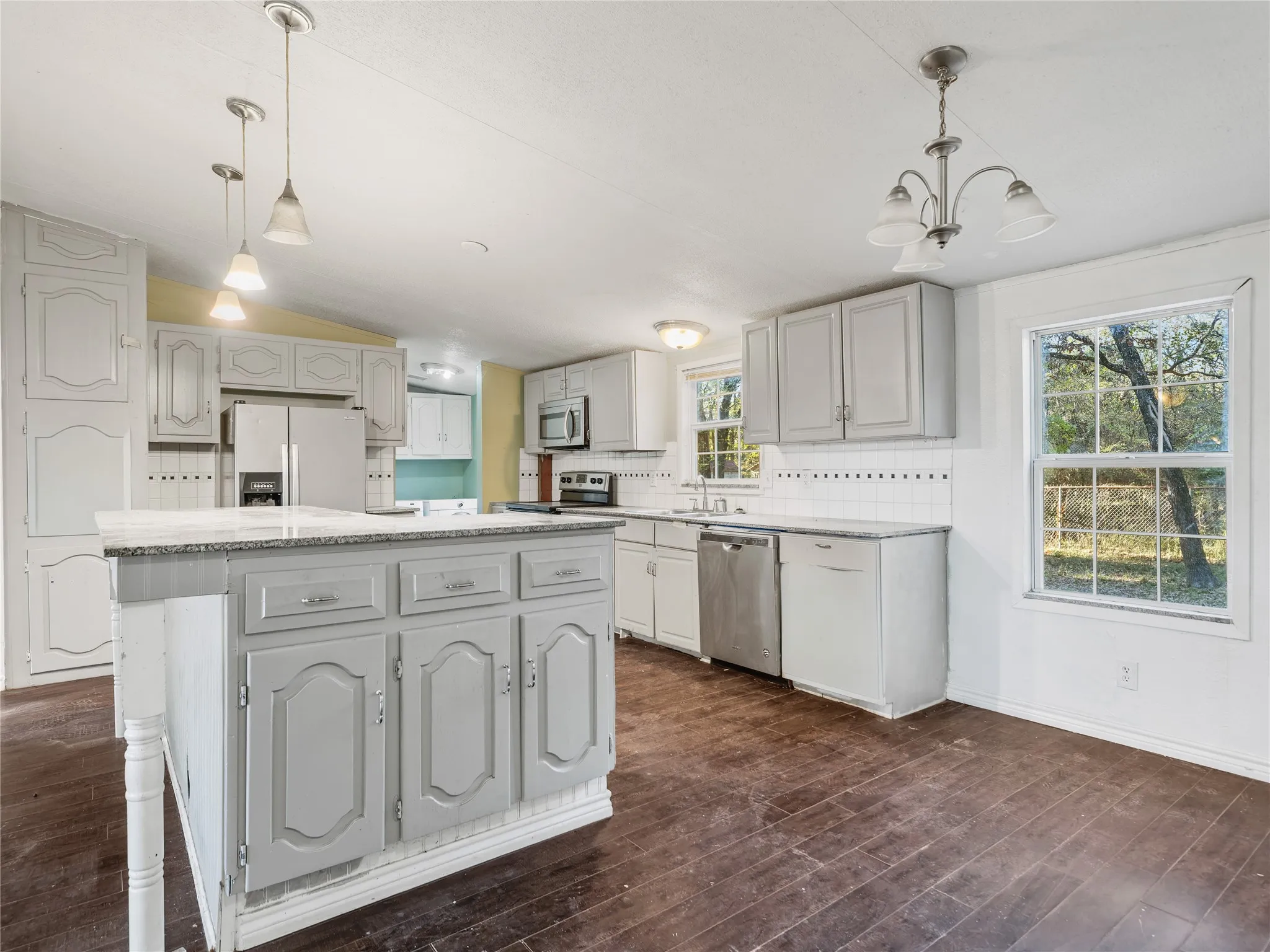 Kitchen with a central island, stainless steel appliances, and white cabinetry