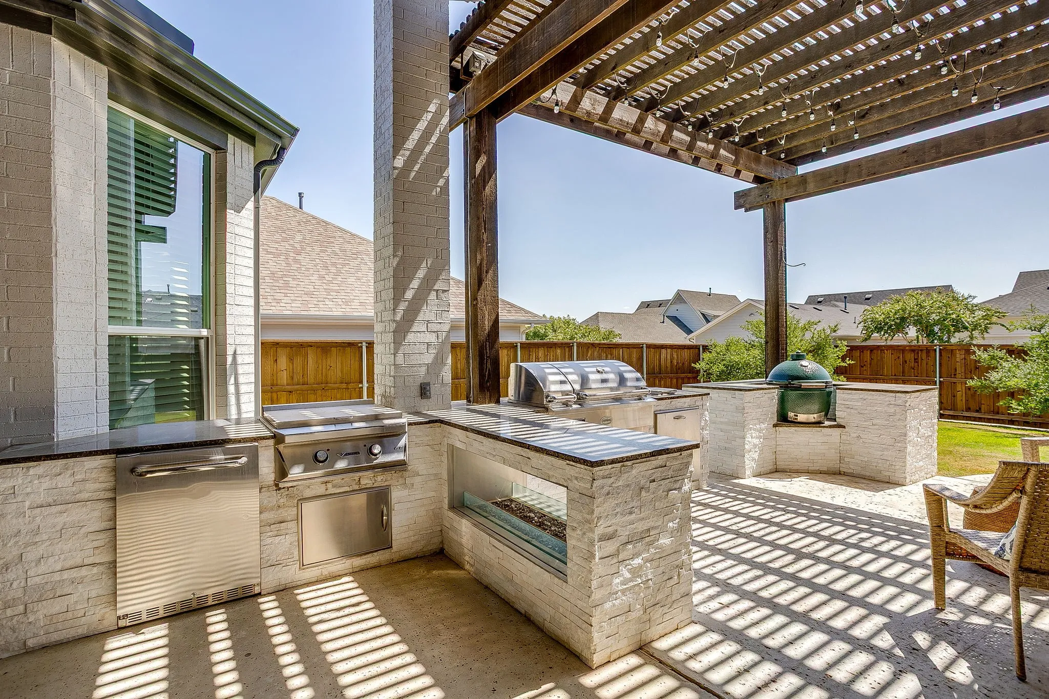 Custom outdoor kitchen with flat top griddle, fireplace, gas grill & green egg!