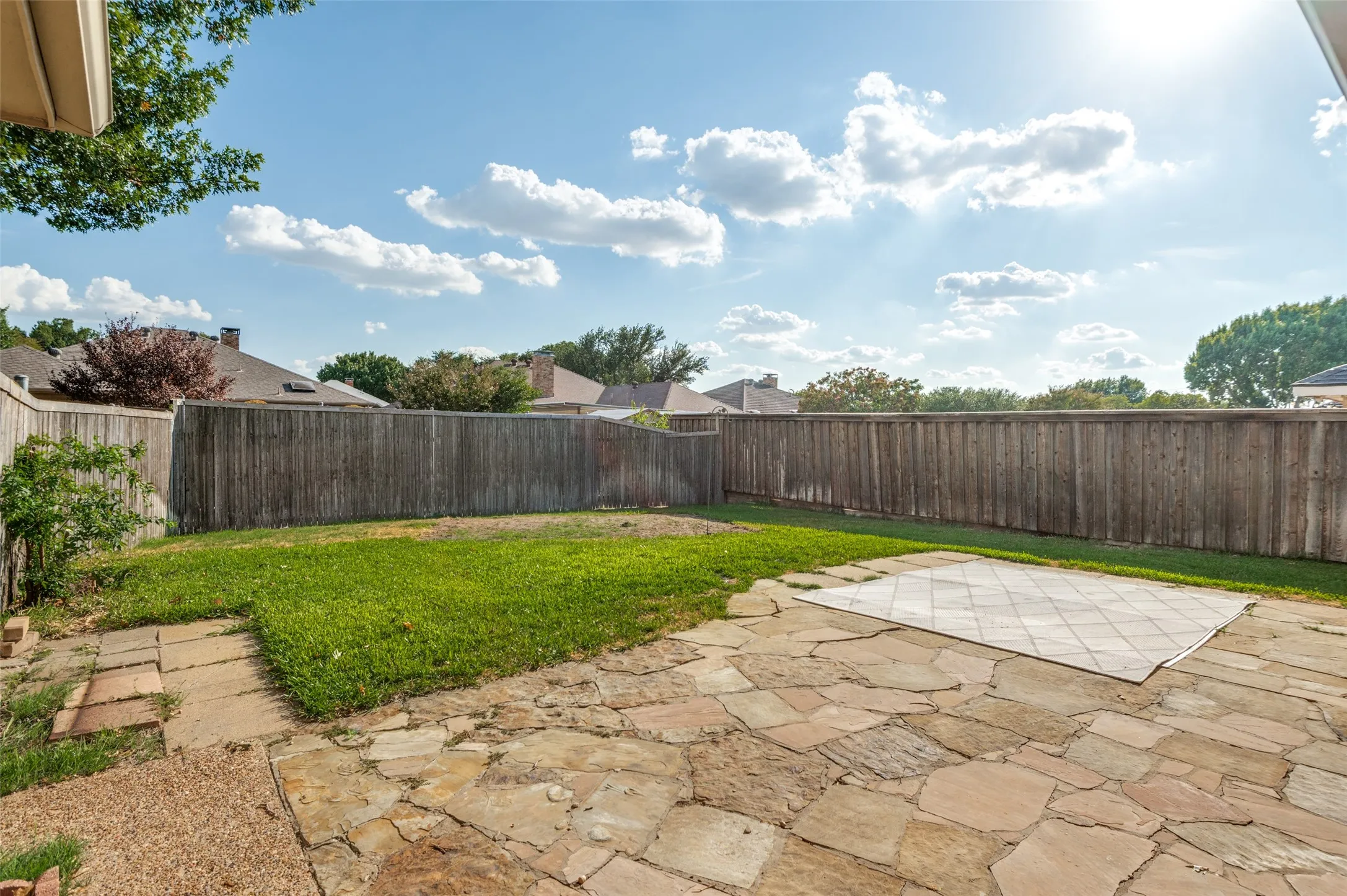 Large back yard flows from covered patio and flagstone Extension