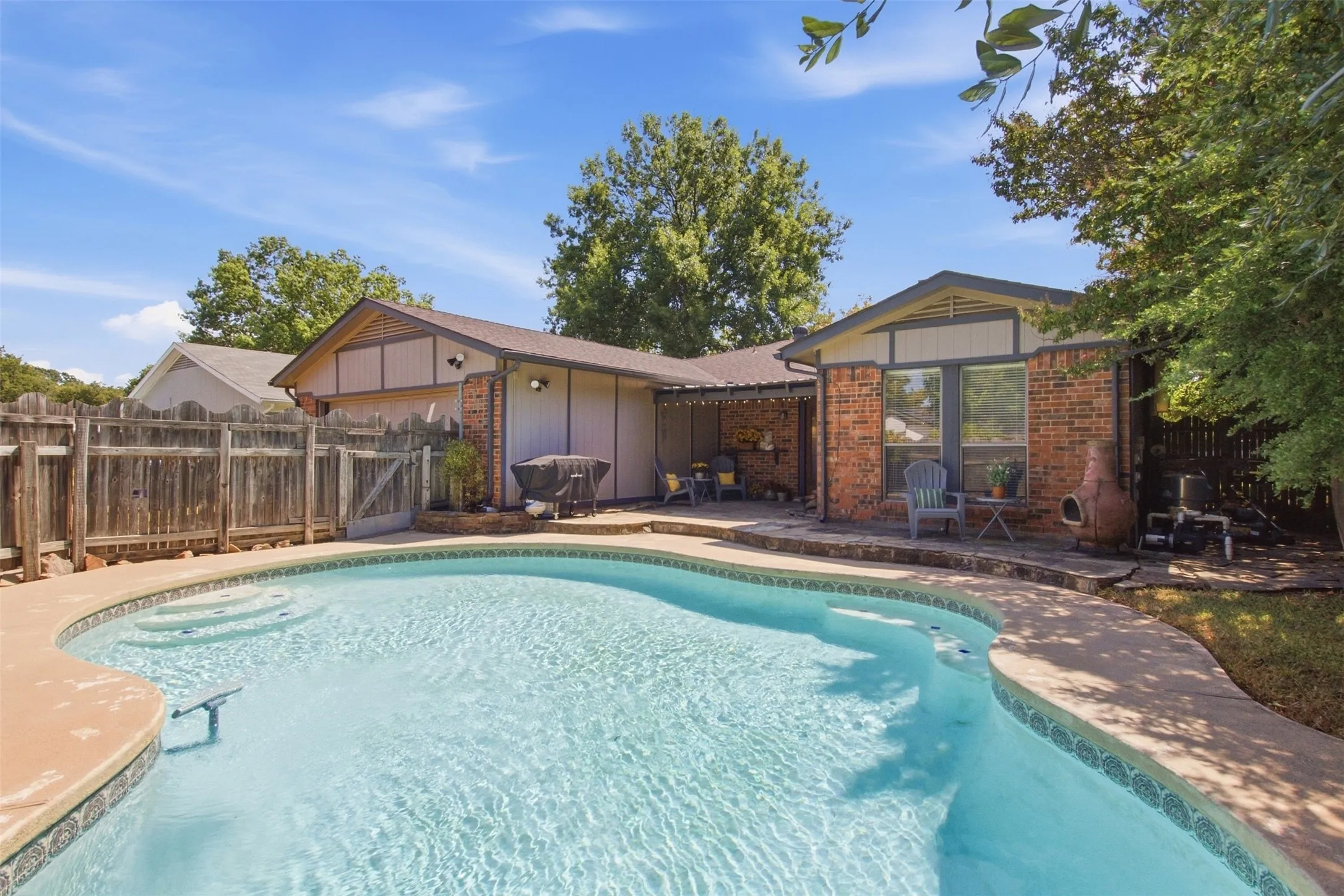 Inviting swimming pool with integrated steps, surrounded by stone coping