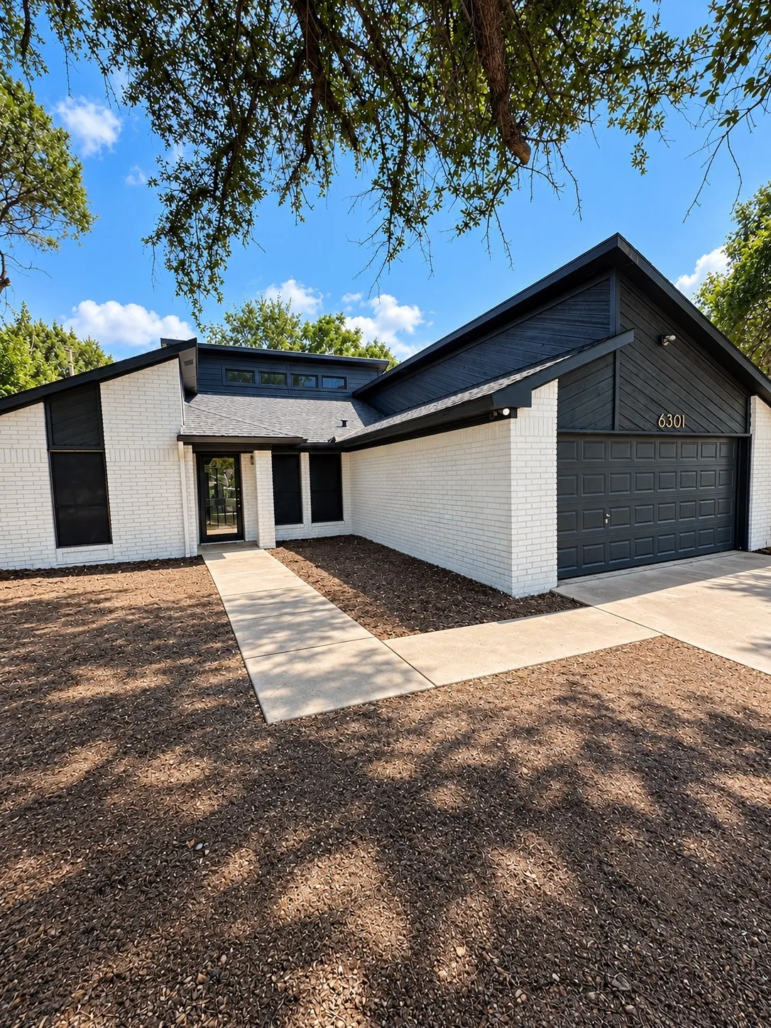 Contemporary exterior featuring white brick and dark siding