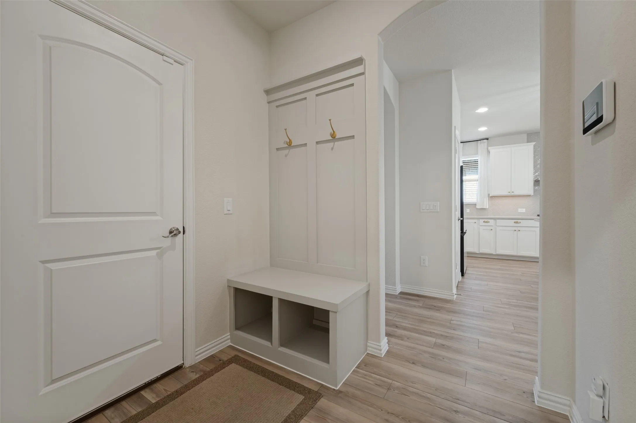 Built-in mudroom bench with storage, panel detailing, and coat hooks