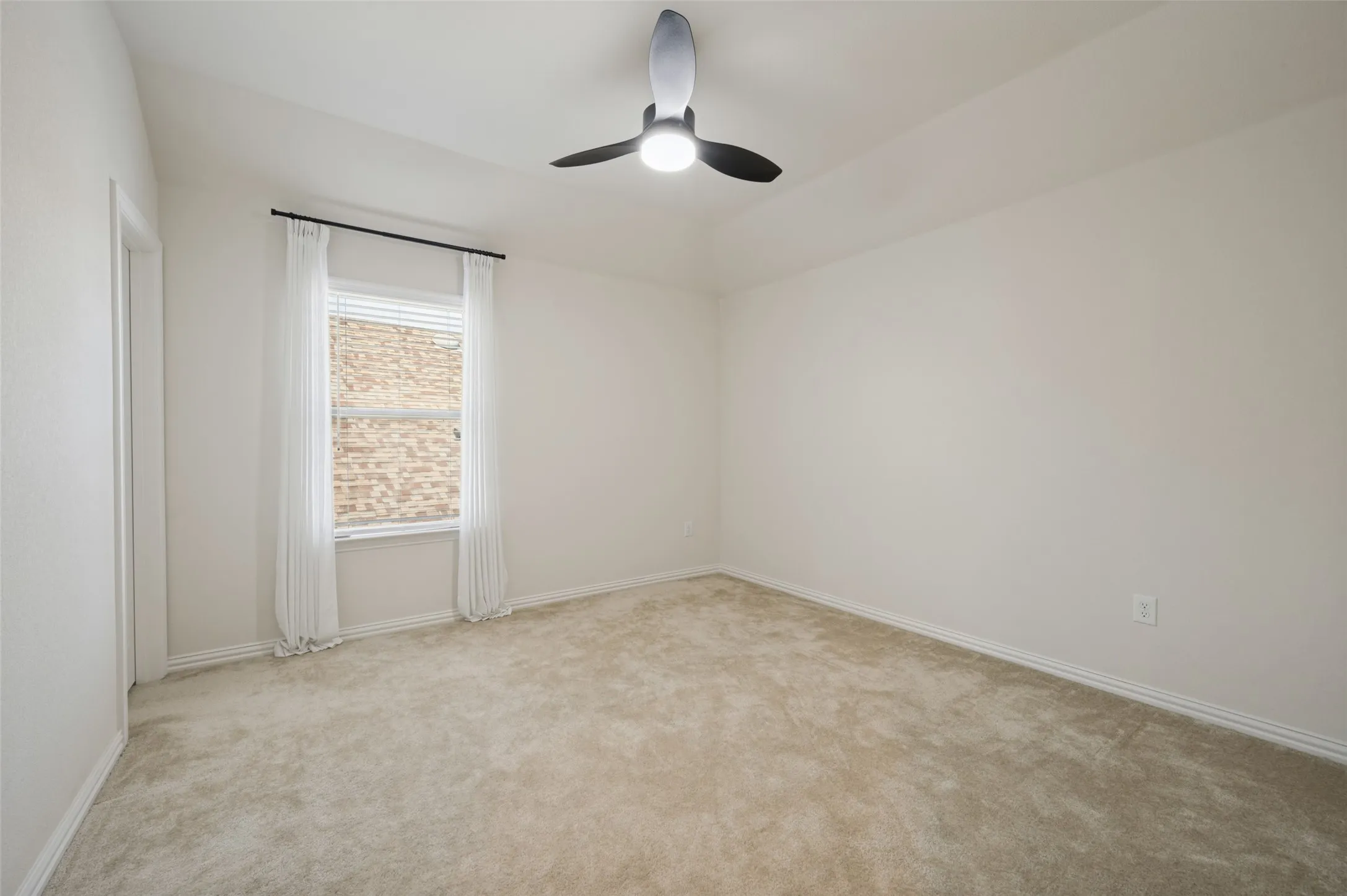 Carpeted room featuring a ceiling fan with integrated lighting