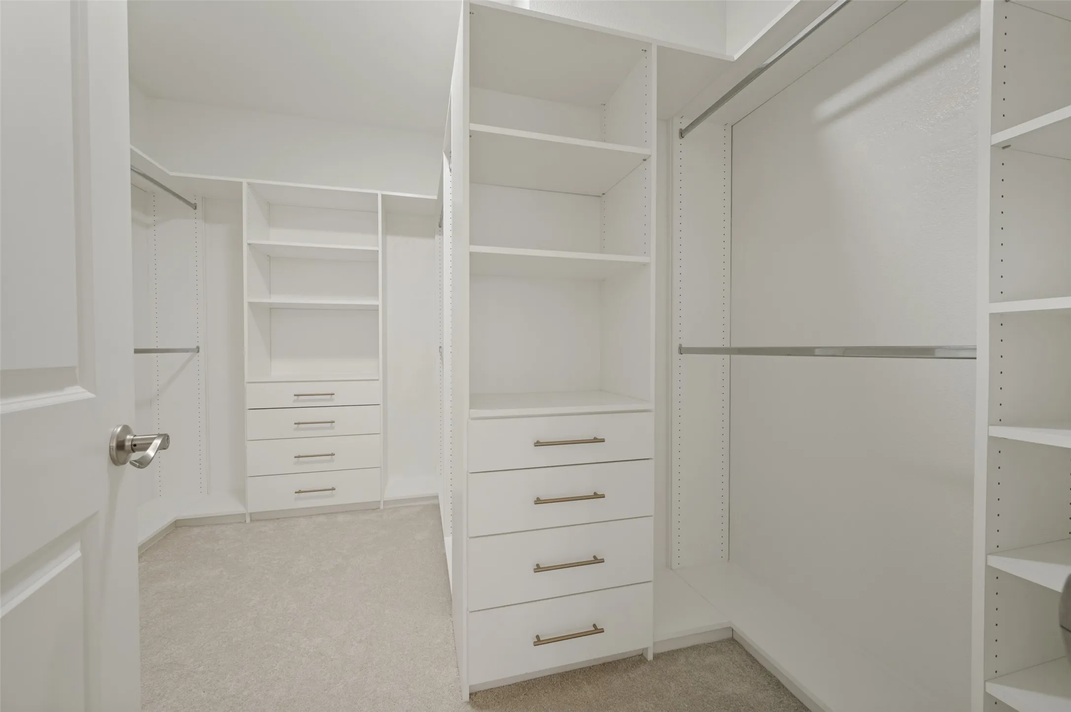 Customizable closet organization system with multiple shelving units, integrated drawers featuring brushed nickel hardware, and ample hanging rods