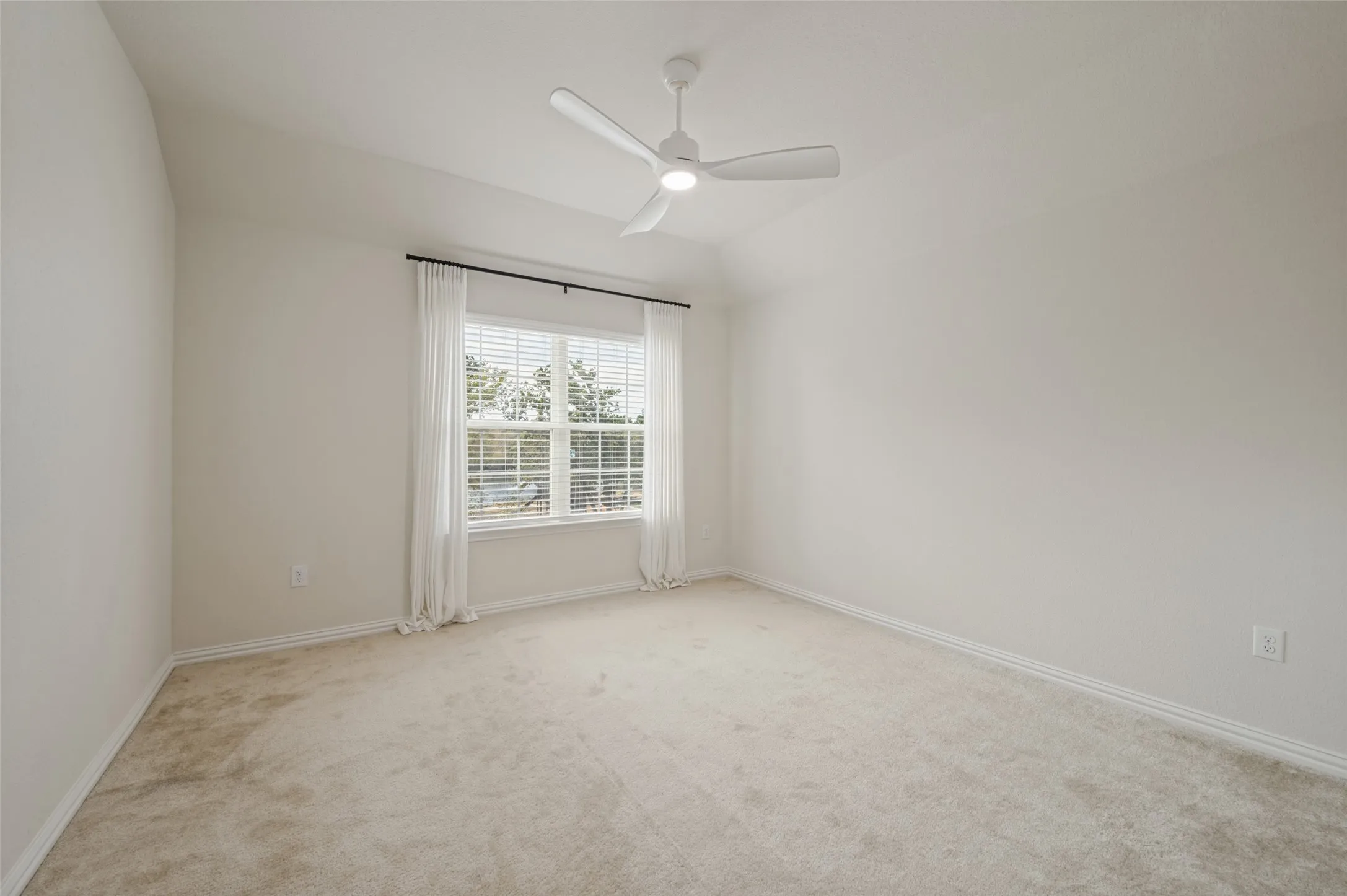 Room featuring a ceiling fan, neutral carpet flooring, and a window with blinds