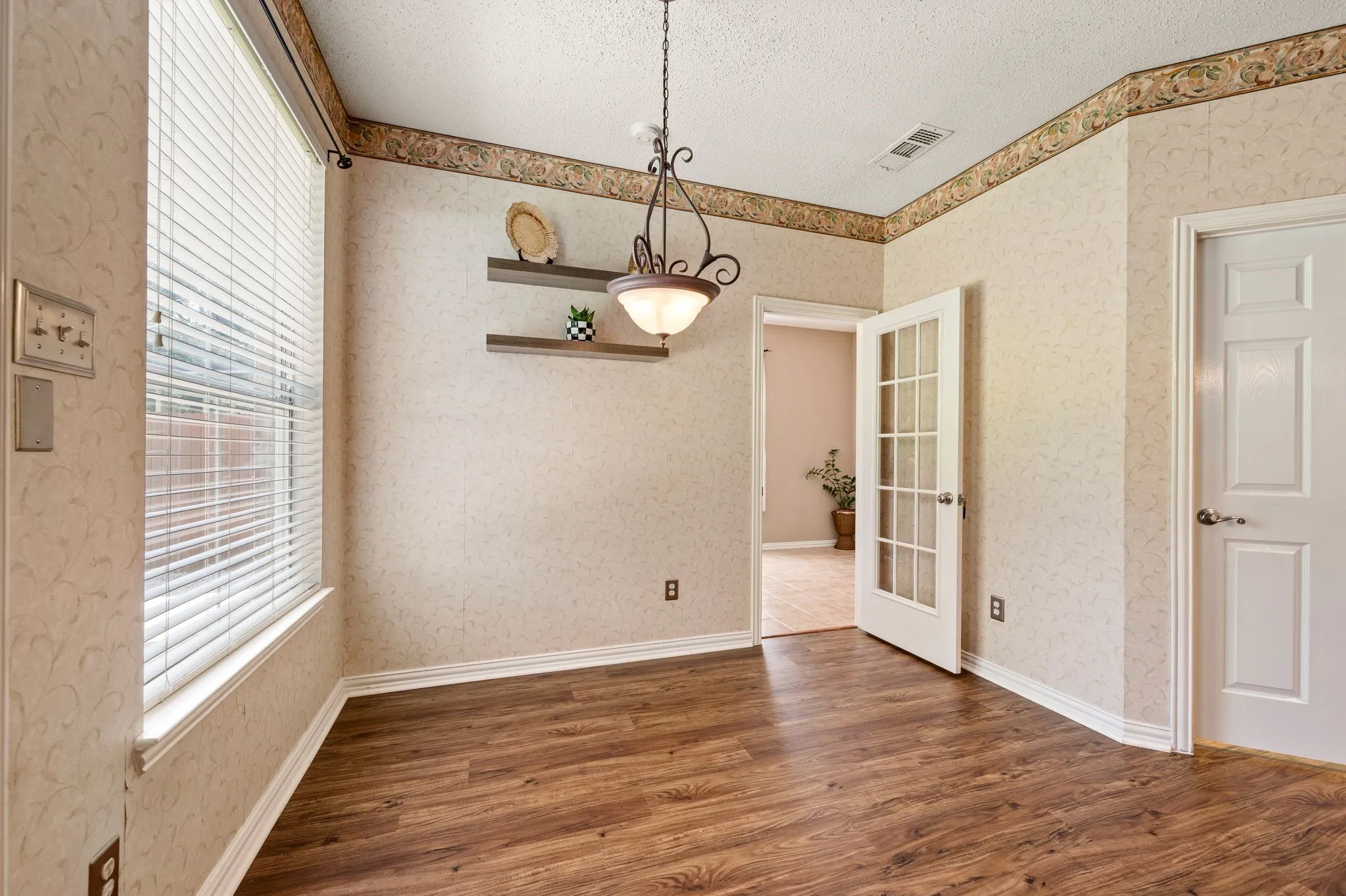Wood-finish flooring, overhead lighting fixture, and French doors