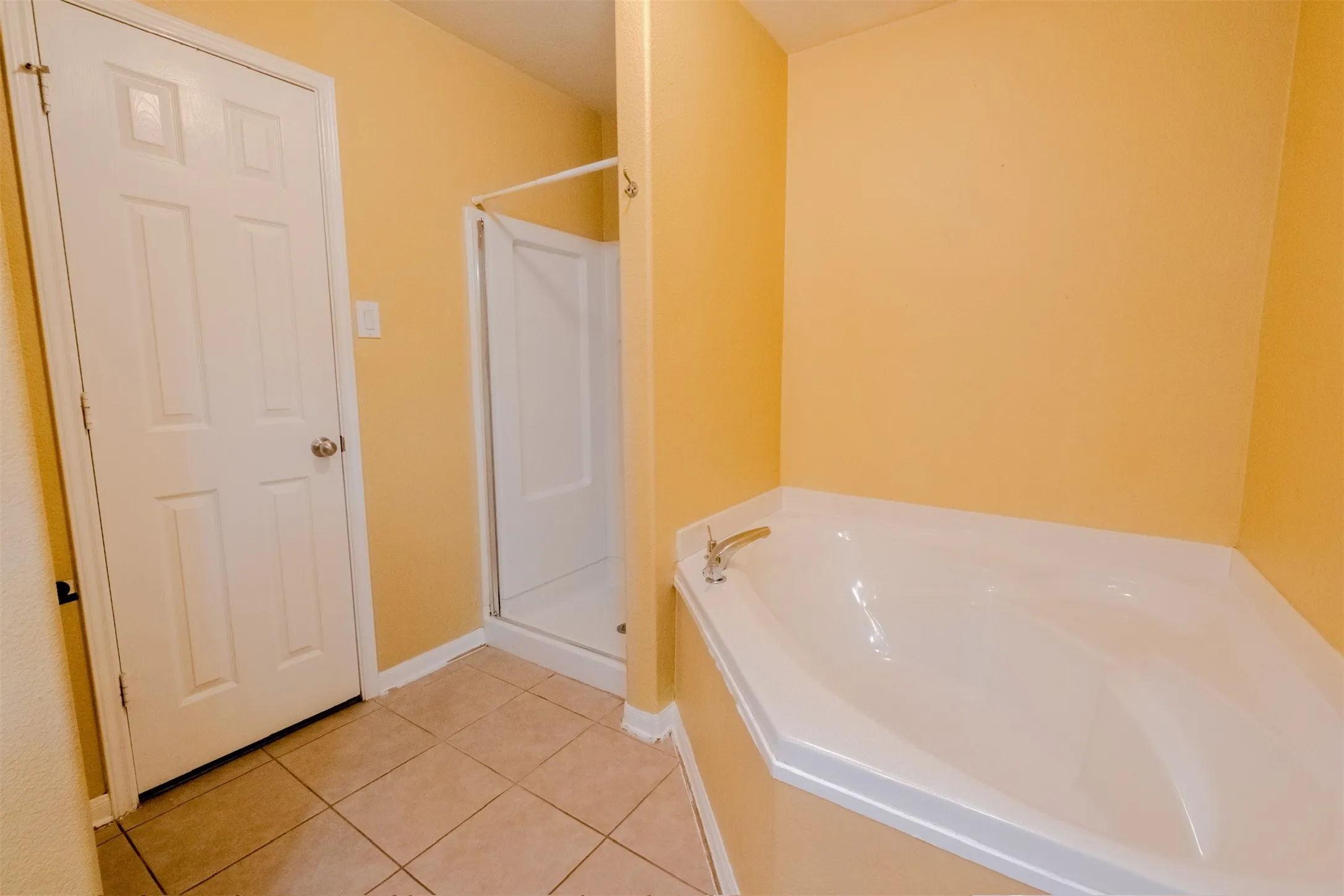 Full bath with light tile patterned floors, a garden tub, and a stall shower