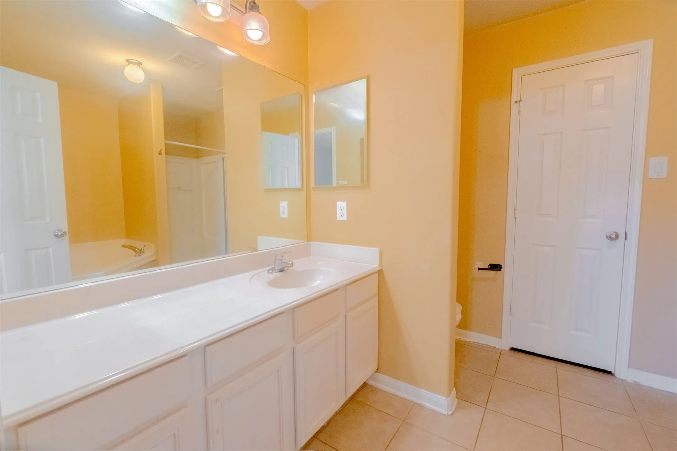 Bathroom featuring light tile patterned floors, vanity, a shower, and a bathtub