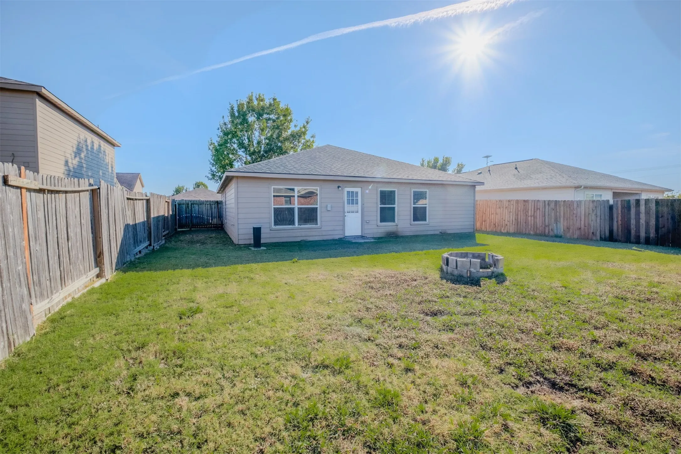 Rear view of house with a fenced backyard