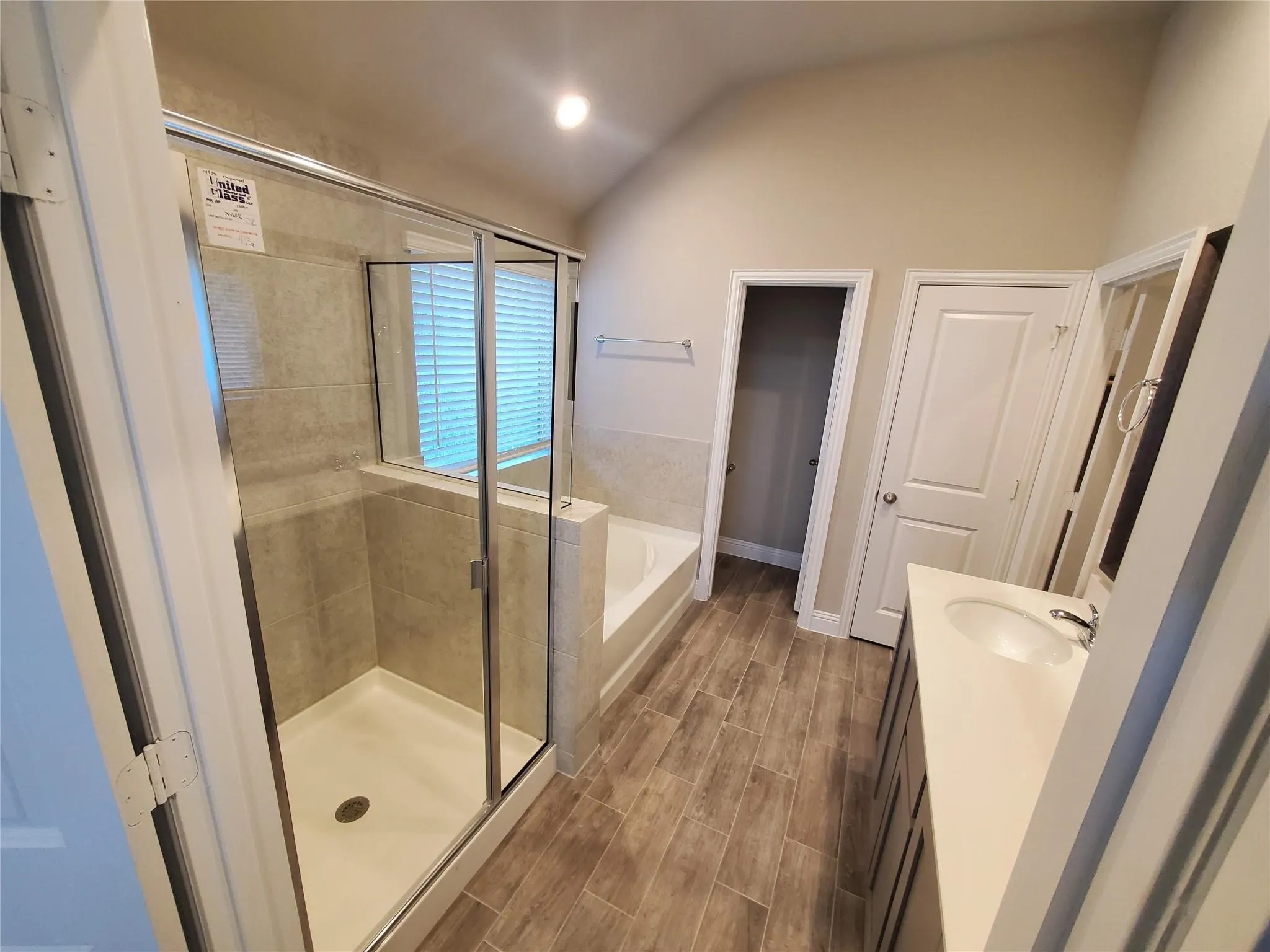 Walk-in shower with clear glass enclosure and tiled walls