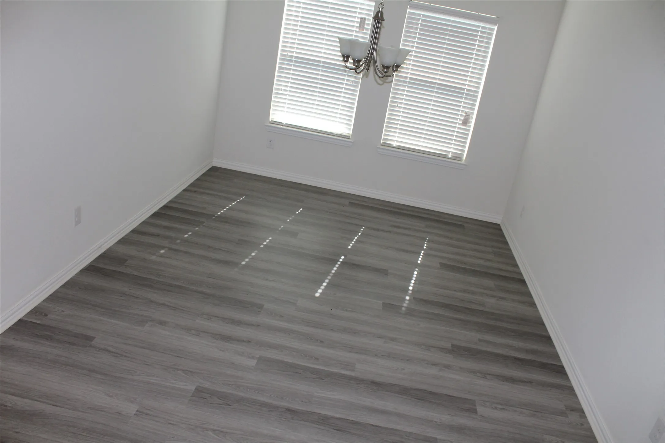Recessed lighting, wood-finish flooring, white walls, and a multi-light chandelier