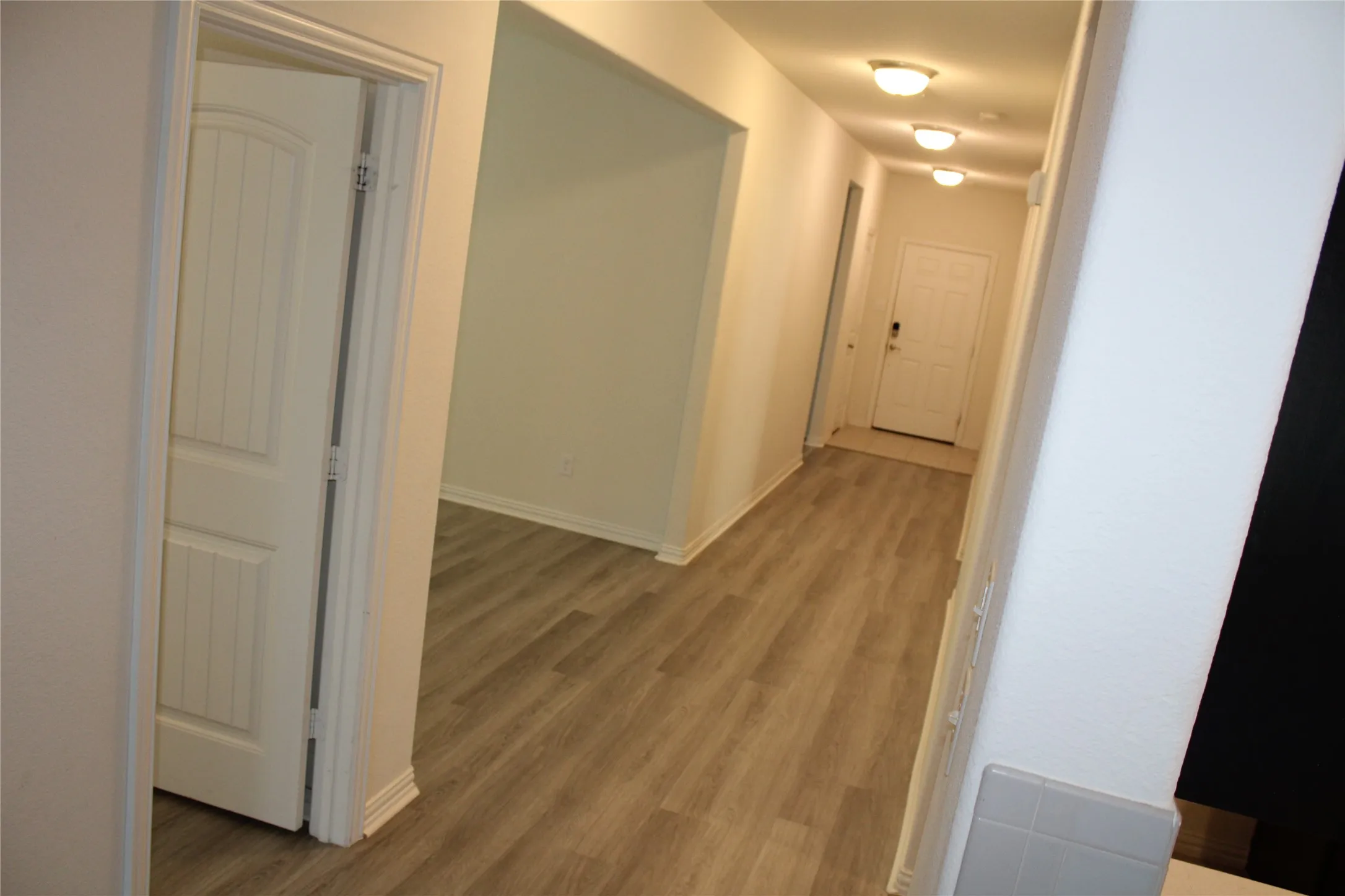 Hallway featuring wood-finish flooring, recessed lighting, and white trim