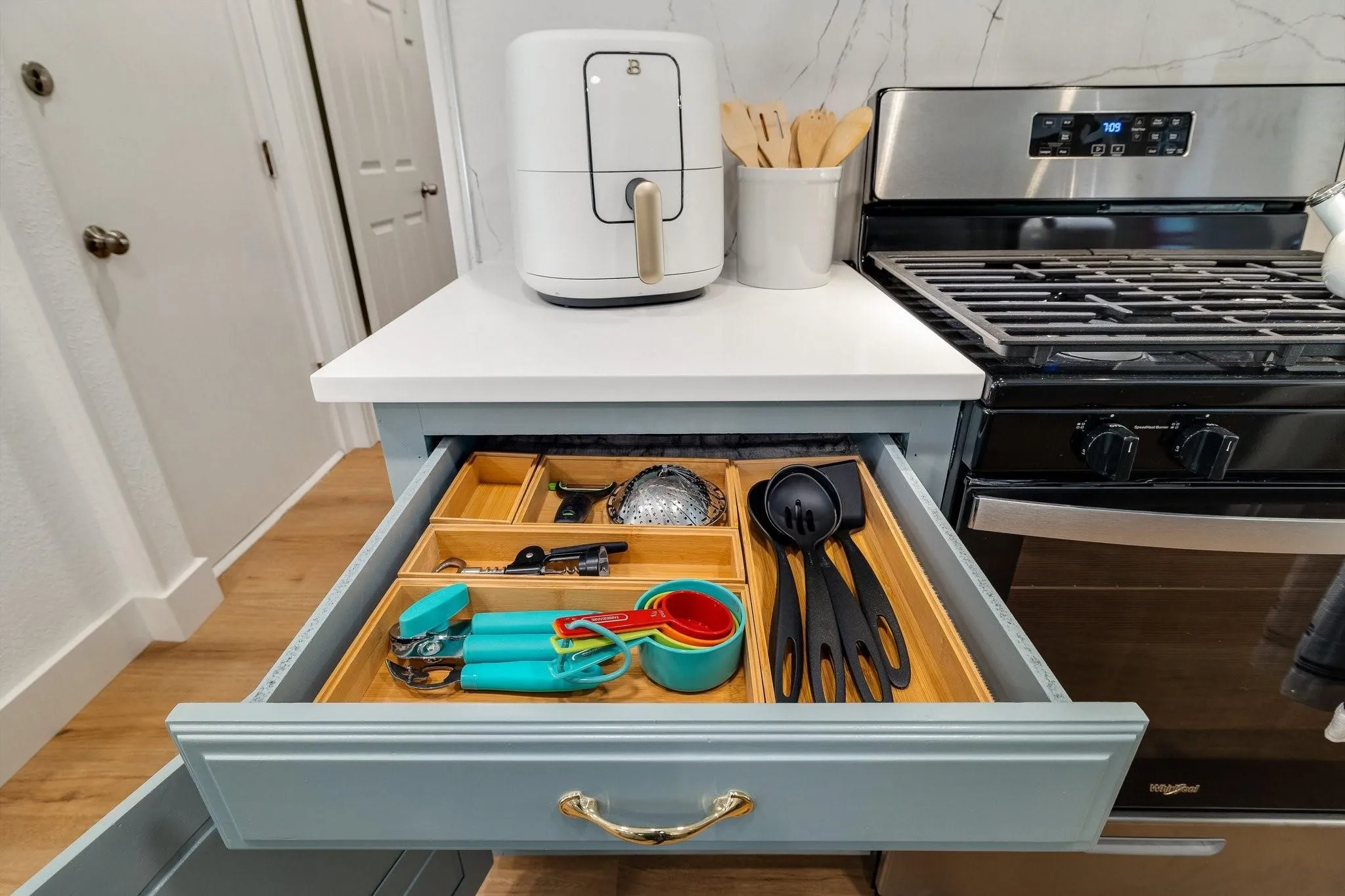 Wood-finish flooring with white trim and a stainless steel range