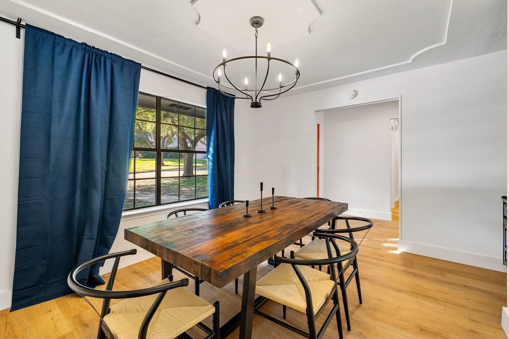 Hardwood flooring, decorative ceiling molding, and a modern chandelier