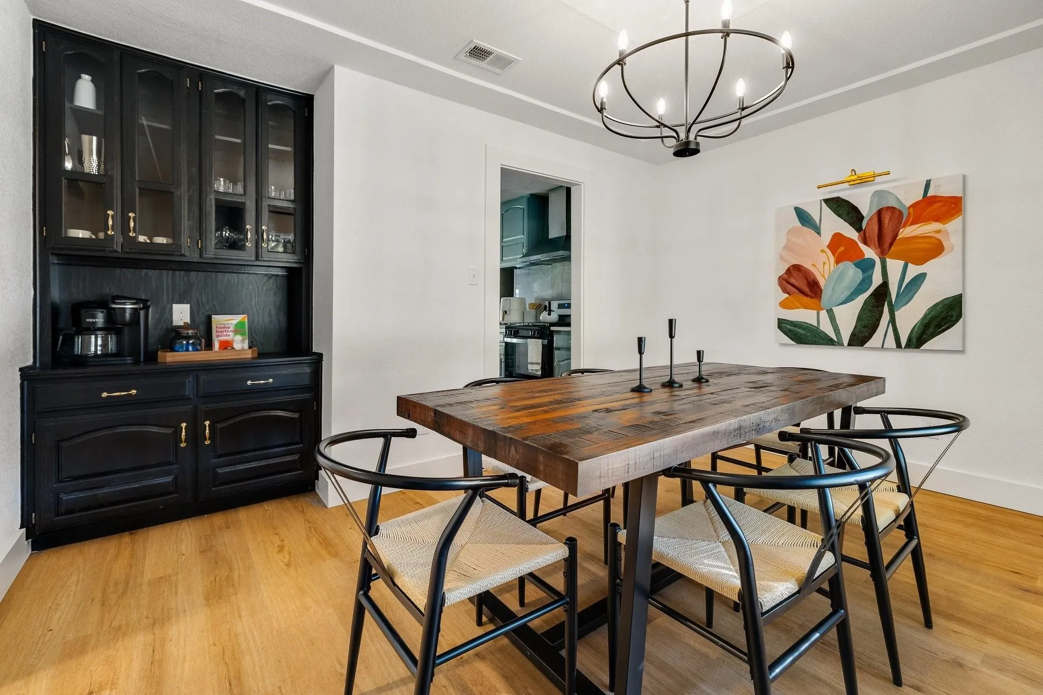Built-in black cabinetry with glass-front uppers, wood-finish flooring, and a contemporary chandelier